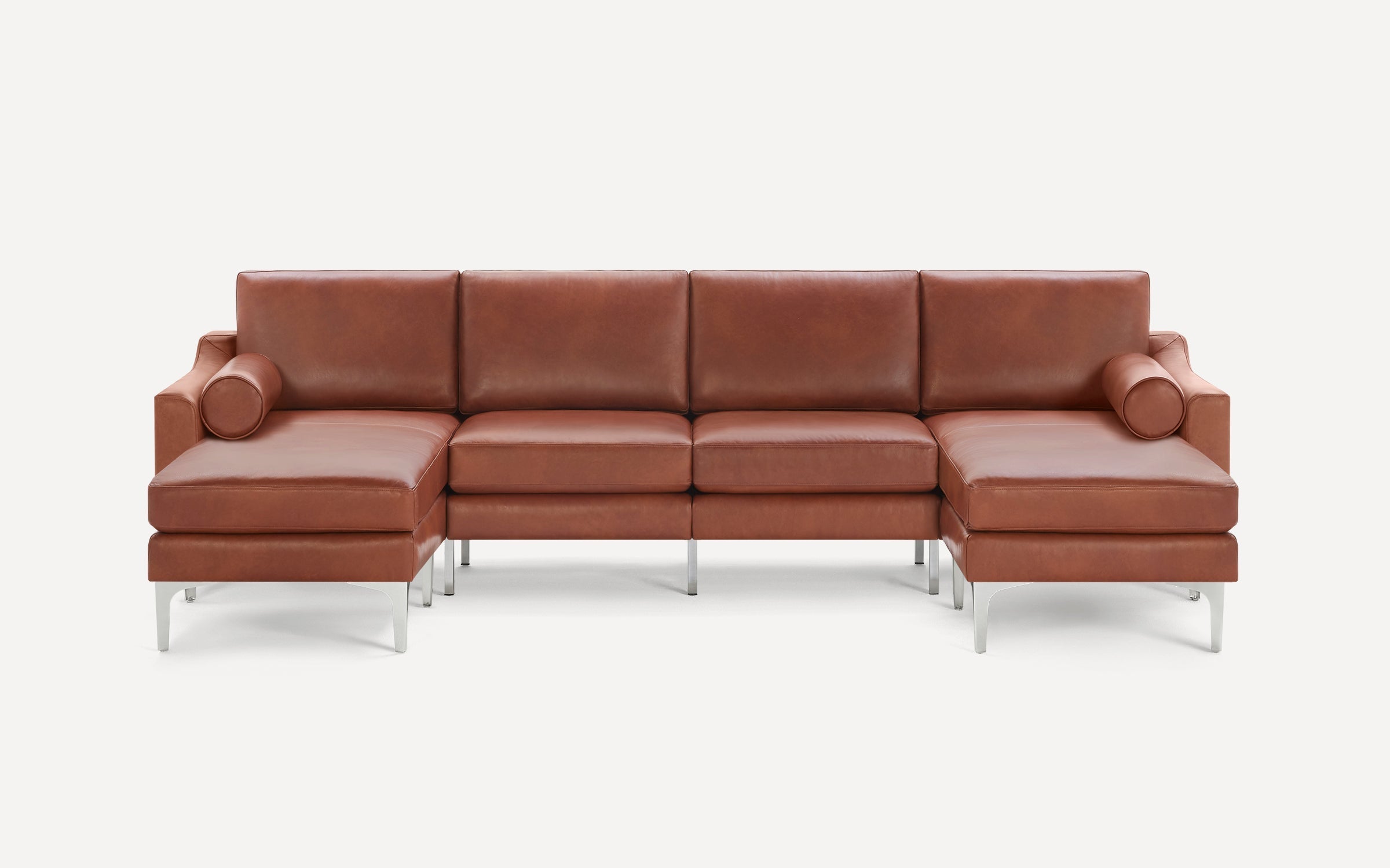 Modern brown leather sectional sofa with chrome legs, featuring two chaise lounges and cylindrical bolster pillows on each end.