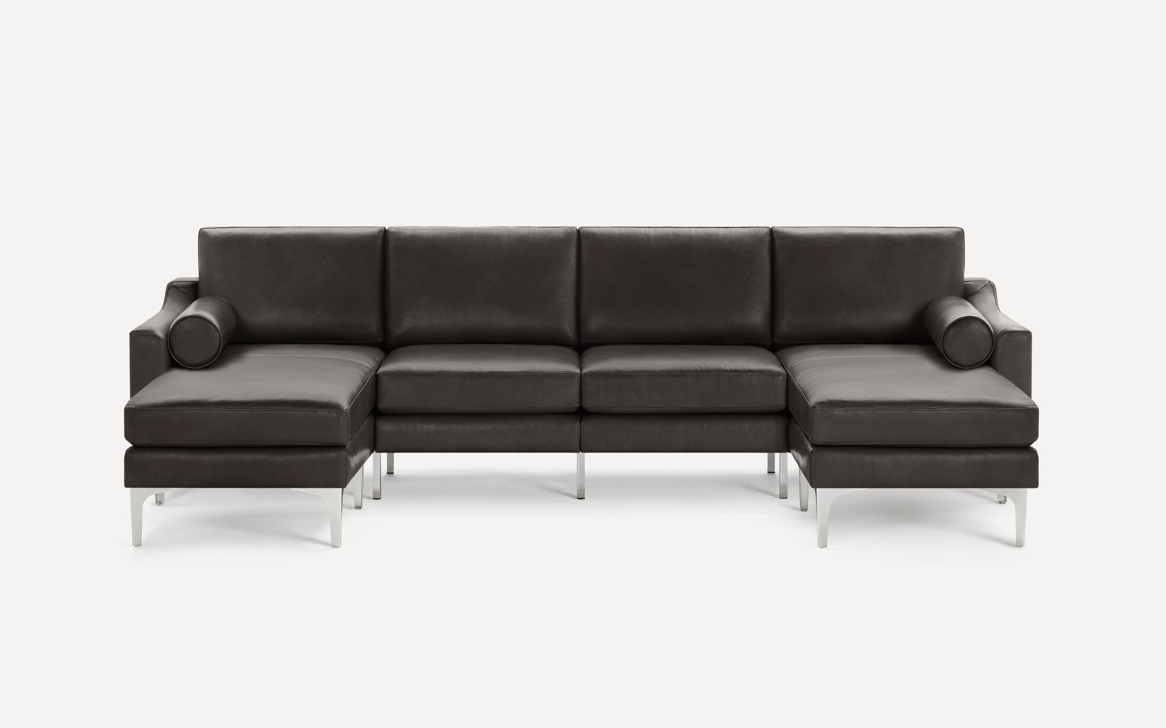 Modern dark brown leather sectional sofa with metal legs, featuring chaise lounges on both ends and cylindrical bolster pillows.