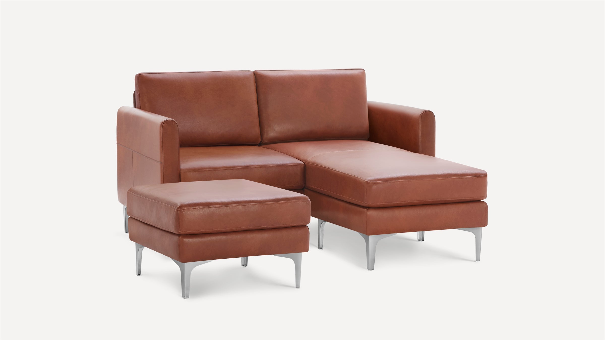 Modern brown leather sectional sofa with chaise lounge and matching ottoman on silver metal legs.