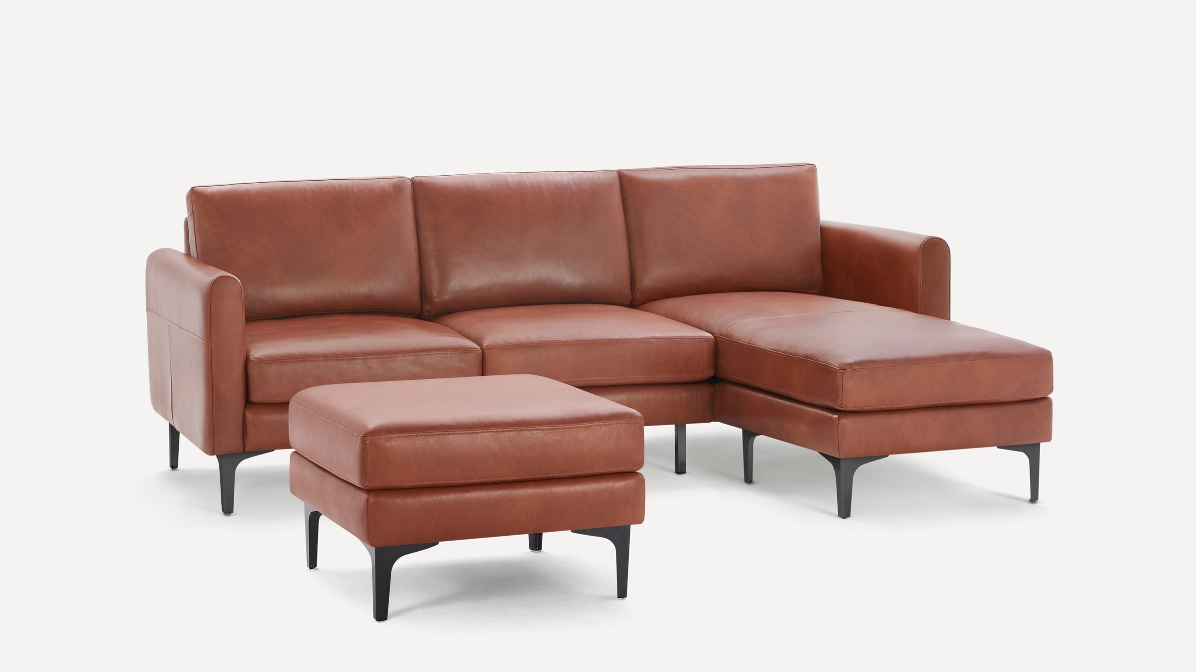 Modern brown leather sectional sofa with chaise lounge and matching ottoman, featuring black metal legs and clean lines.