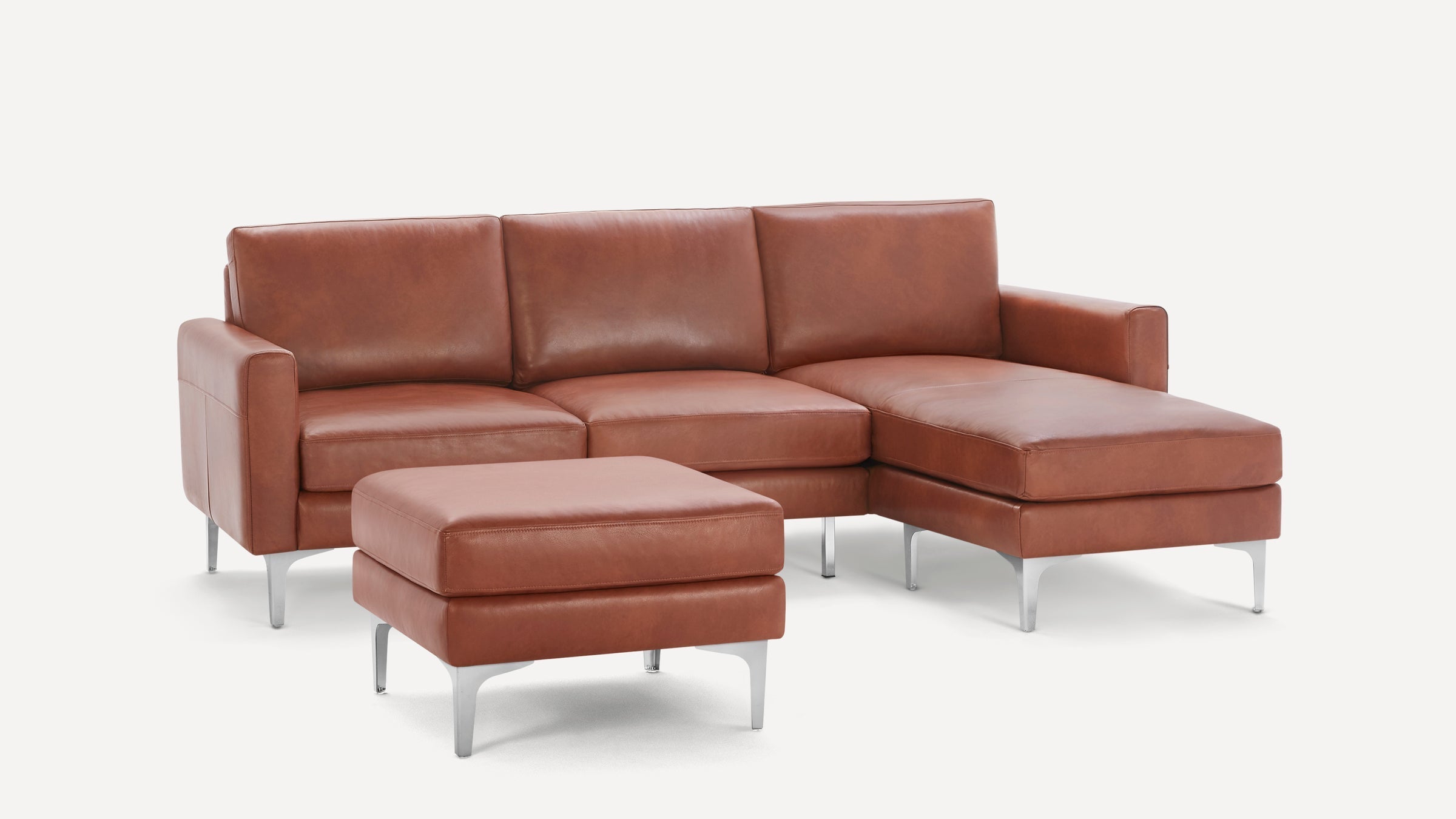 Modern brown leather sectional sofa with chaise lounge and matching ottoman, featuring sleek metal legs and clean lines.