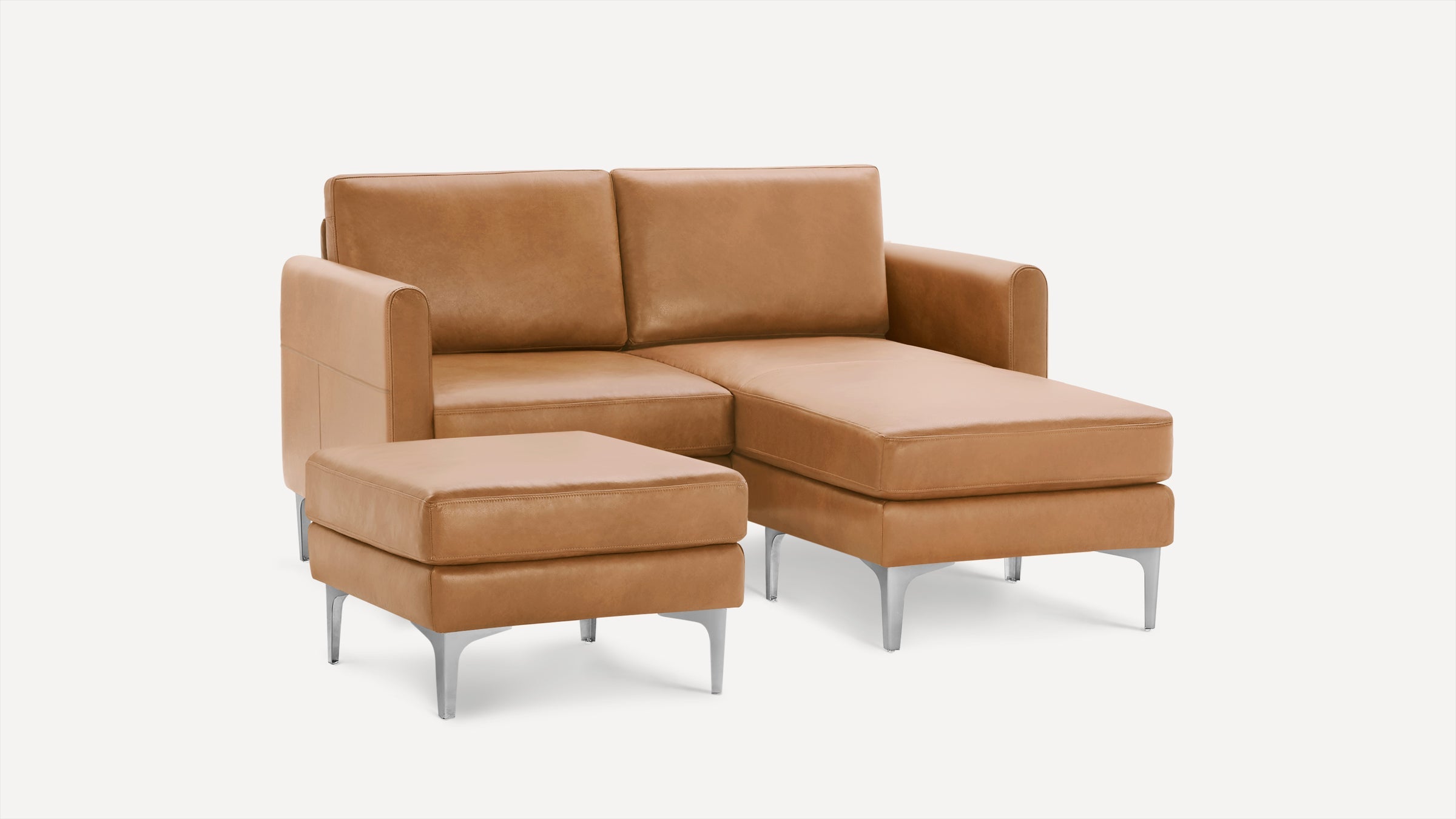 Light brown leather sectional sofa with chaise lounge and matching ottoman, featuring sleek metal legs and clean modern design.