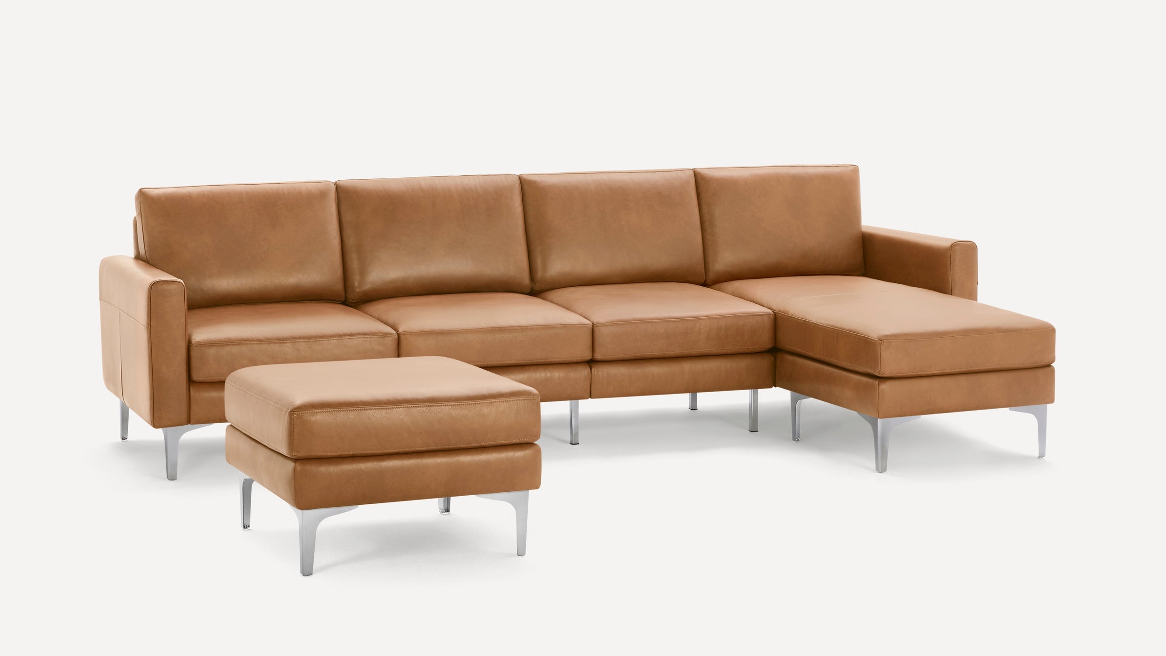 Modern tan leather sectional sofa with chaise lounge and matching ottoman, featuring sleek metal legs and clean lines.