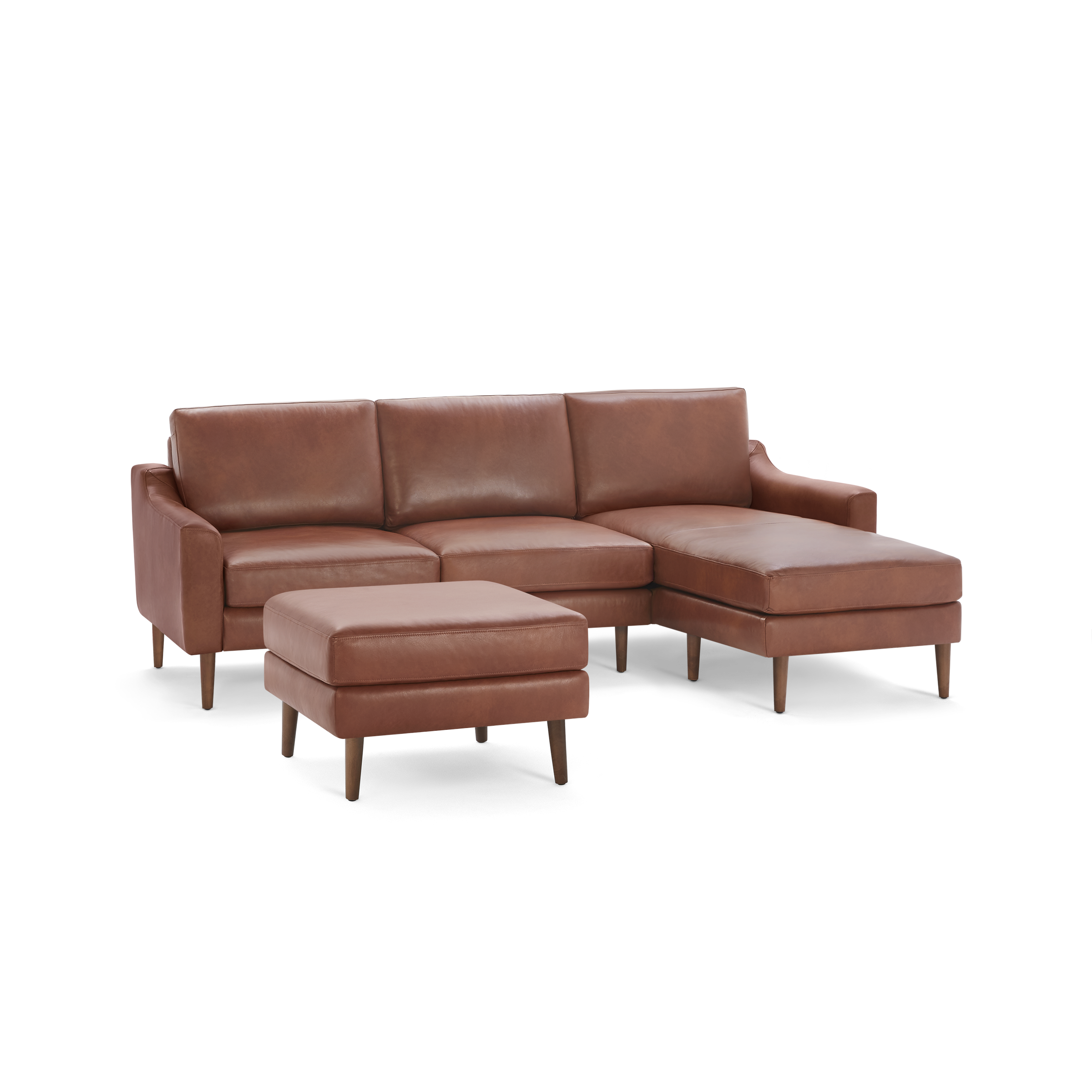 Brown leather sectional sofa with three seats, chaise lounge on the right, and a matching ottoman with wooden legs.