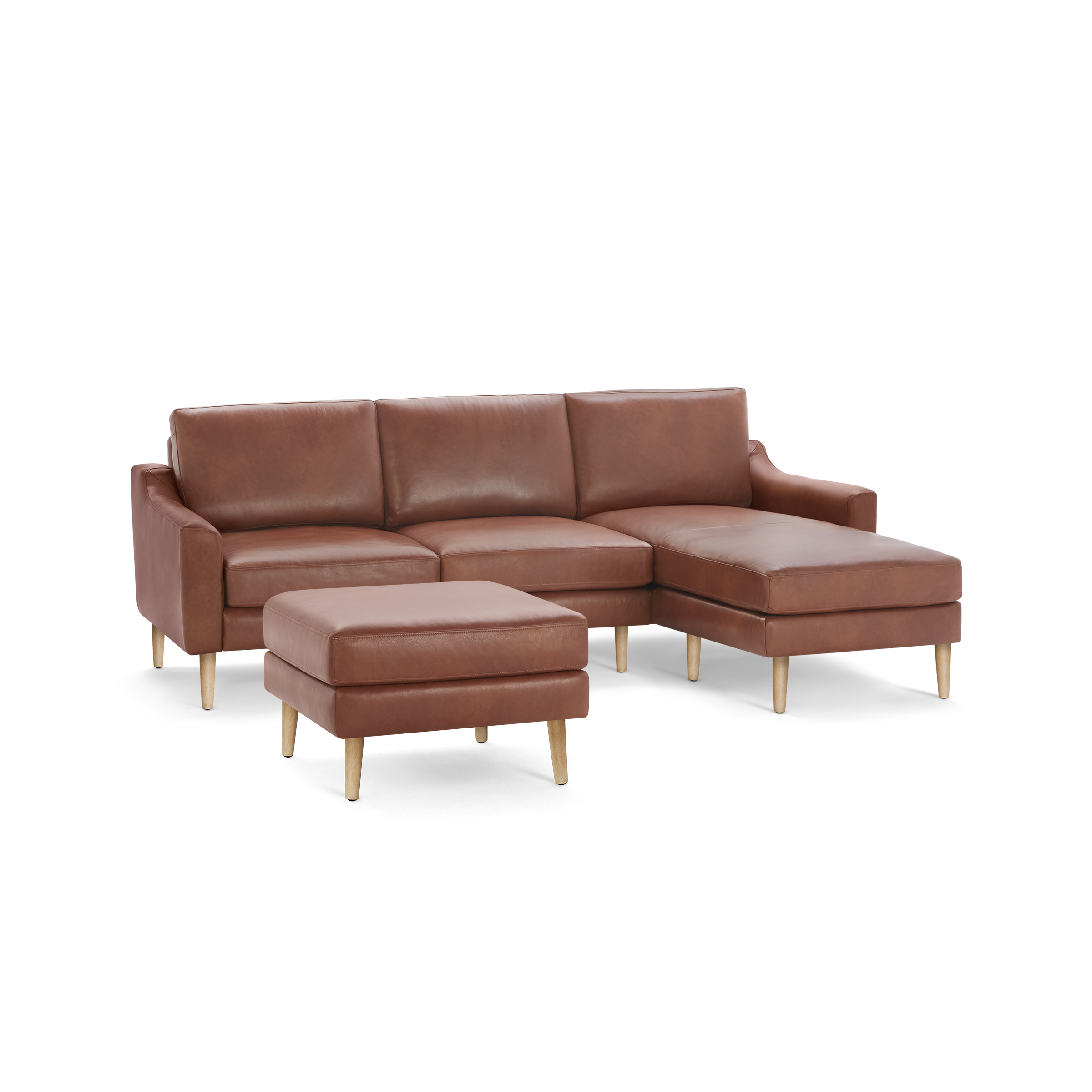 Brown leather sectional sofa with wooden legs, featuring a chaise lounge and matching ottoman.