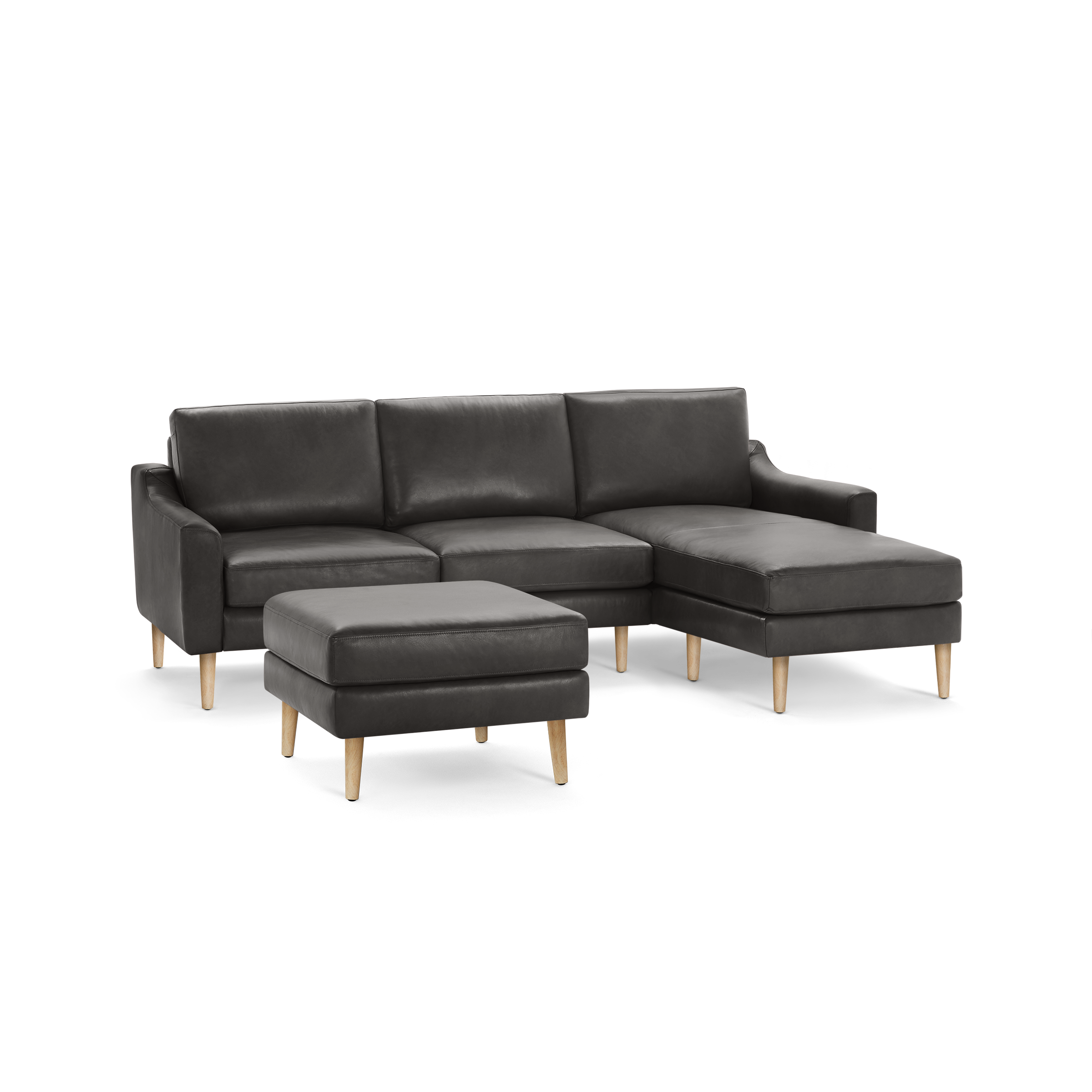 Dark gray leather sectional sofa with chaise lounge and matching ottoman, supported by light wooden legs, modern design.