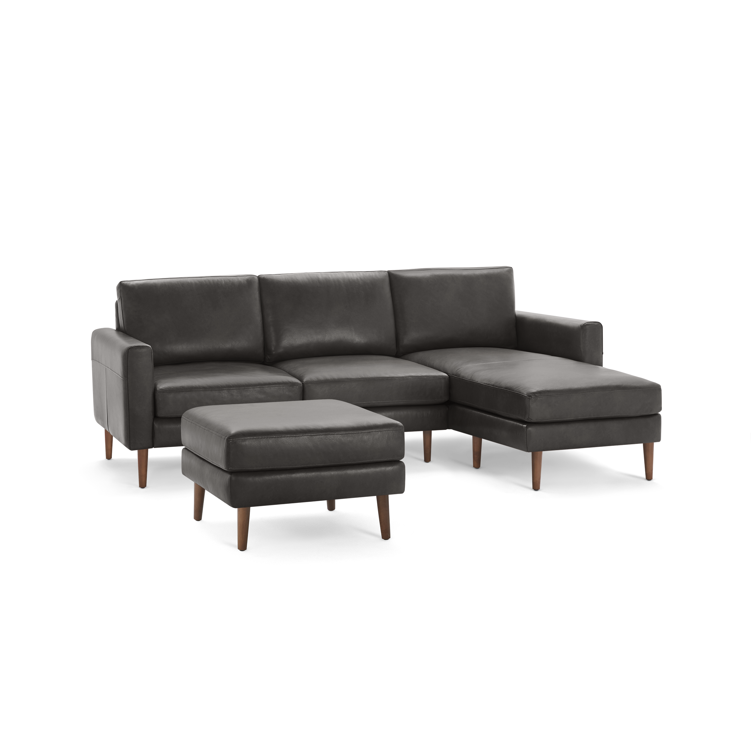 Dark gray leather sectional sofa with matching ottoman, wooden legs, and modern design spacious chaise lounge on right side.