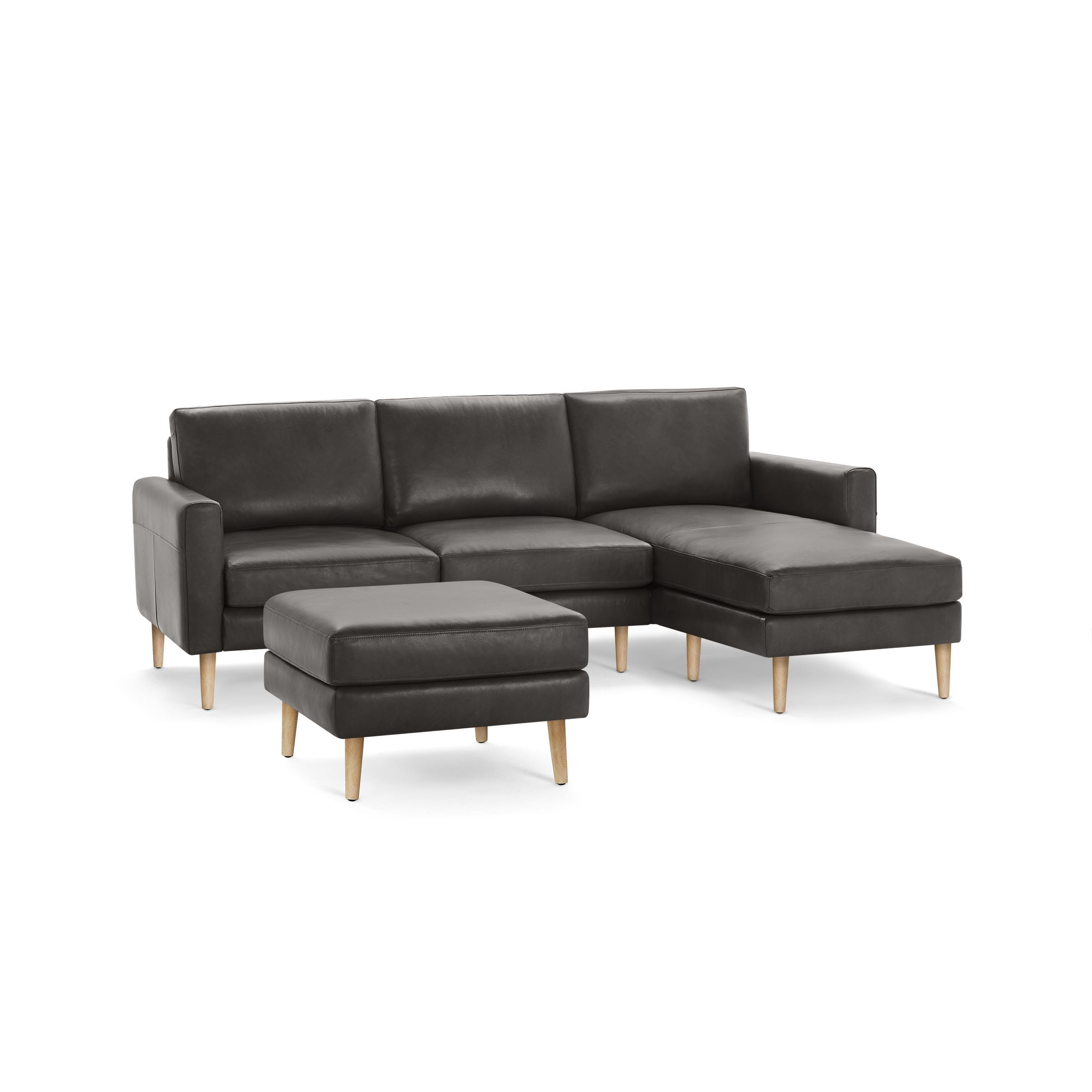 Modern dark gray sectional sofa with wooden legs and matching ottoman, featuring a chaise lounge on the right side.