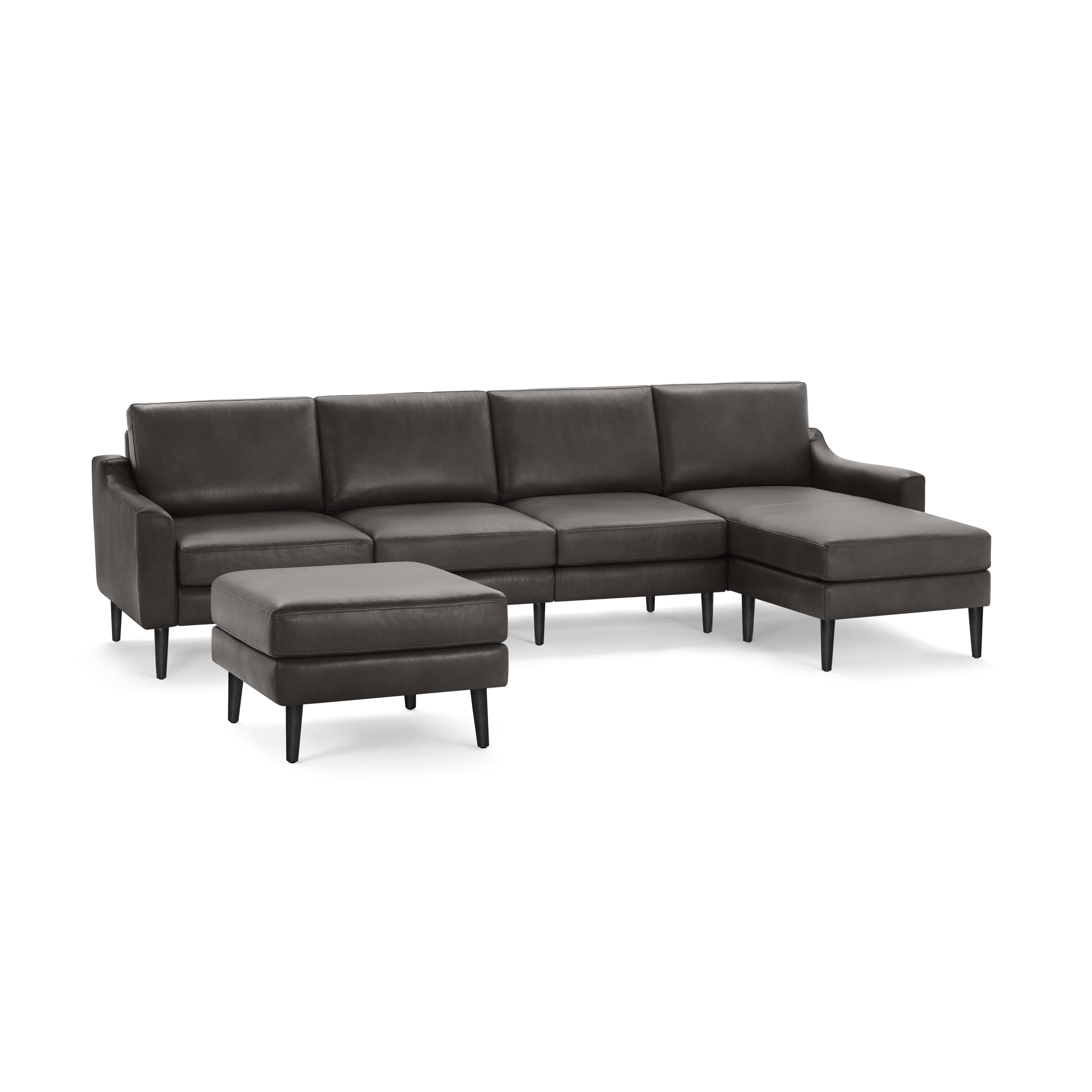 Gray leather sectional sofa with chaise lounge and matching ottoman, featuring tapered black legs and plush cushions.