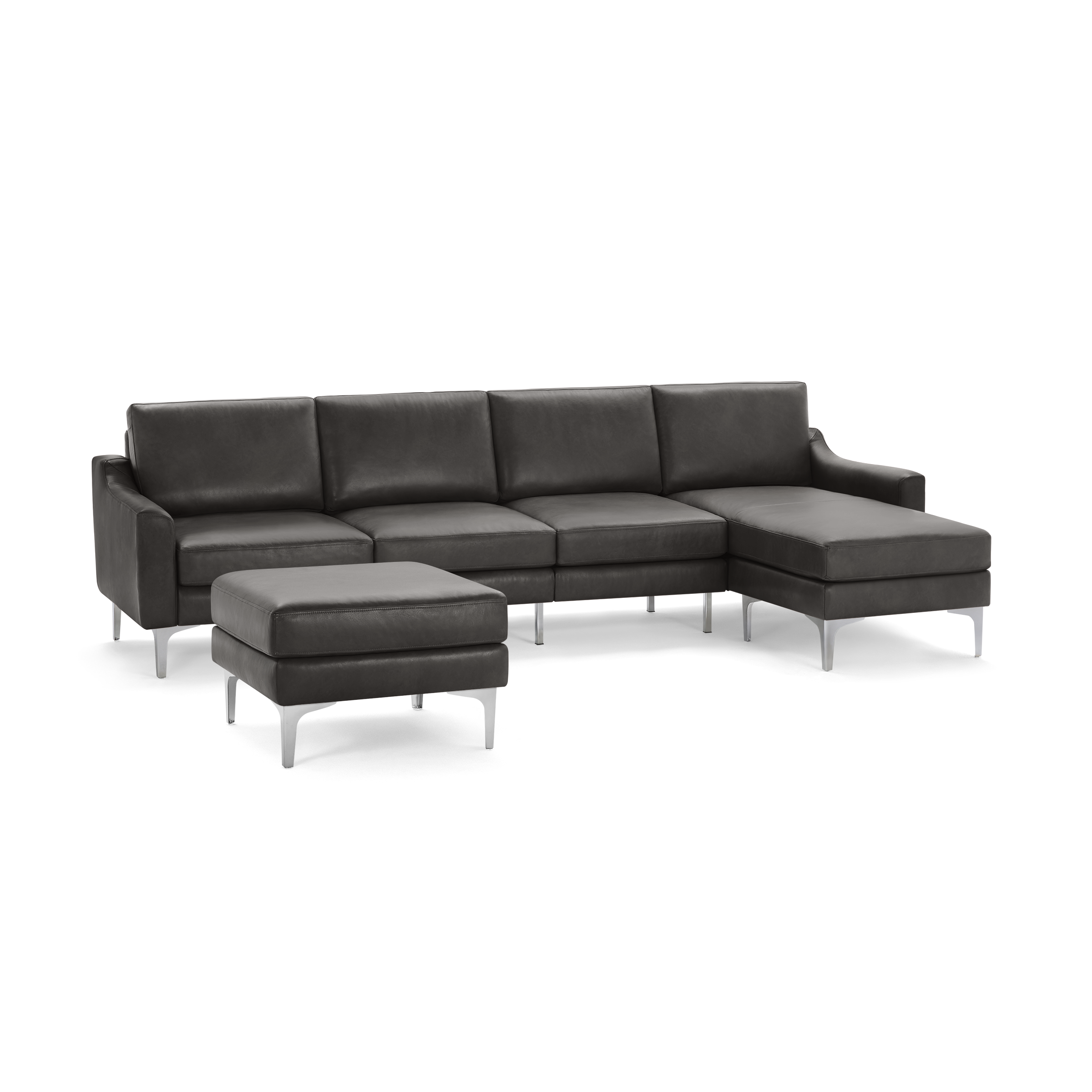 Modern dark gray leather sectional sofa with chaise lounge and matching ottoman, supported by sleek silver metal legs.