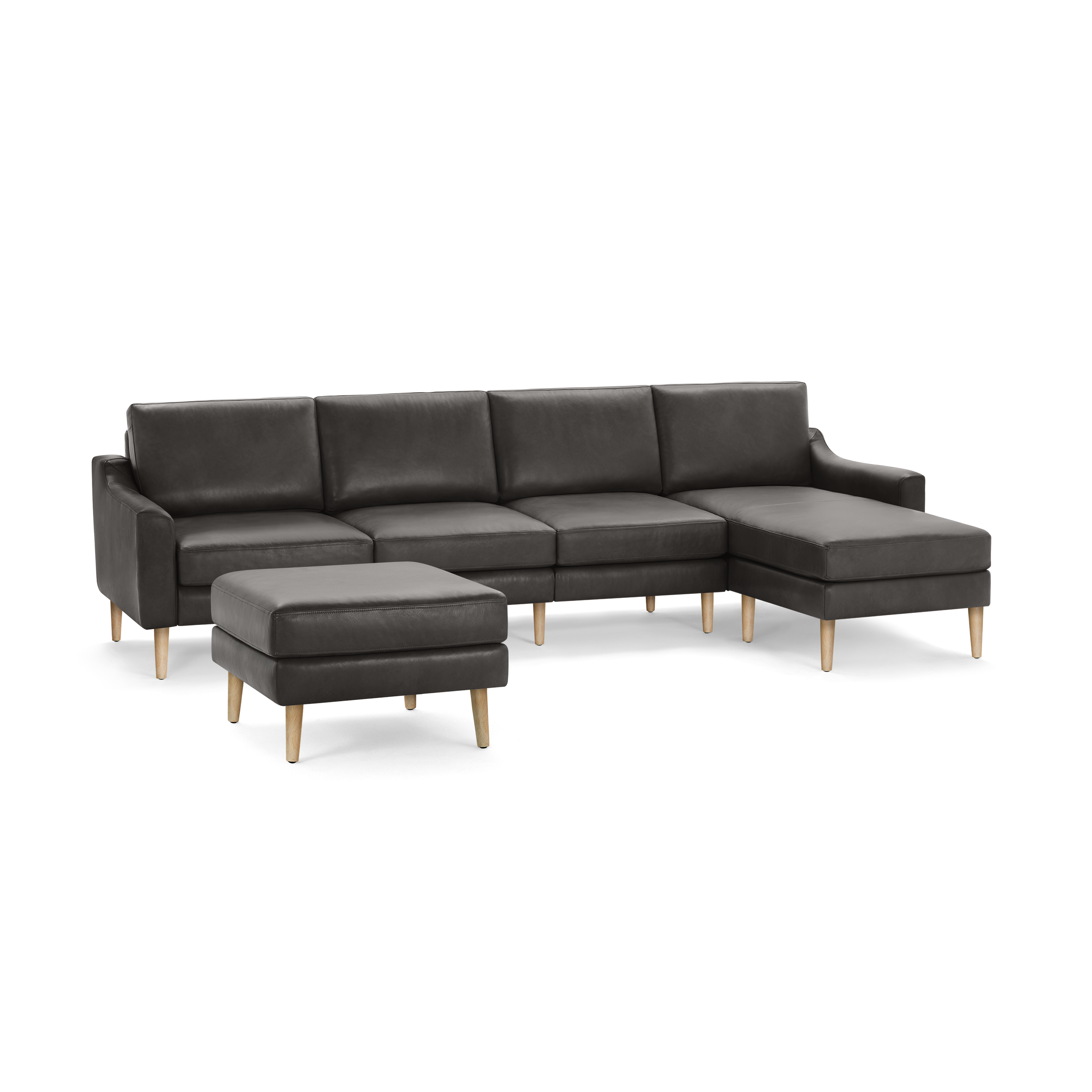 Dark gray leather sectional sofa with matching ottoman, featuring wooden legs and clean, modern design.