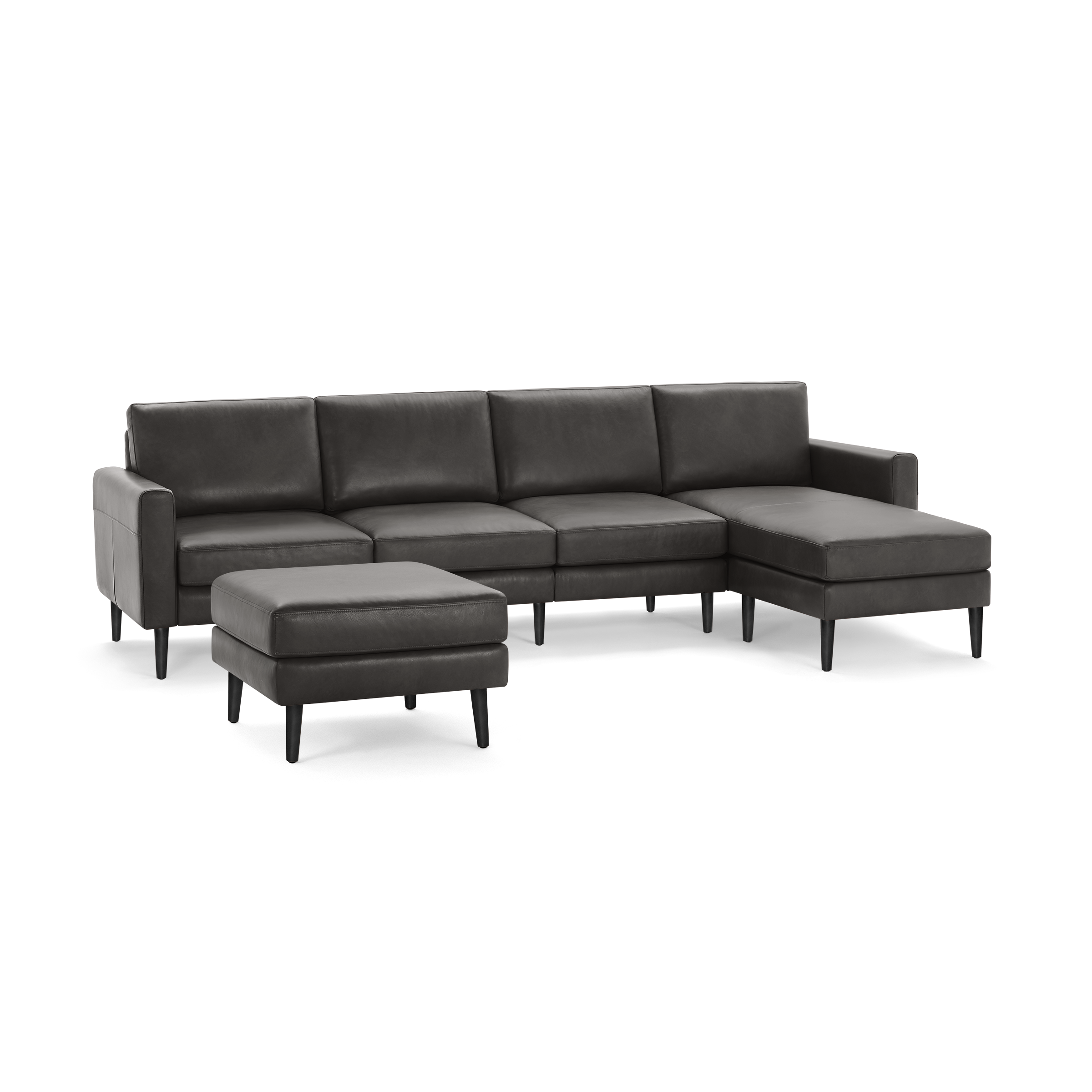 Dark gray leather sectional sofa with chaise lounge and matching ottoman, featuring clean lines and black tapered legs.