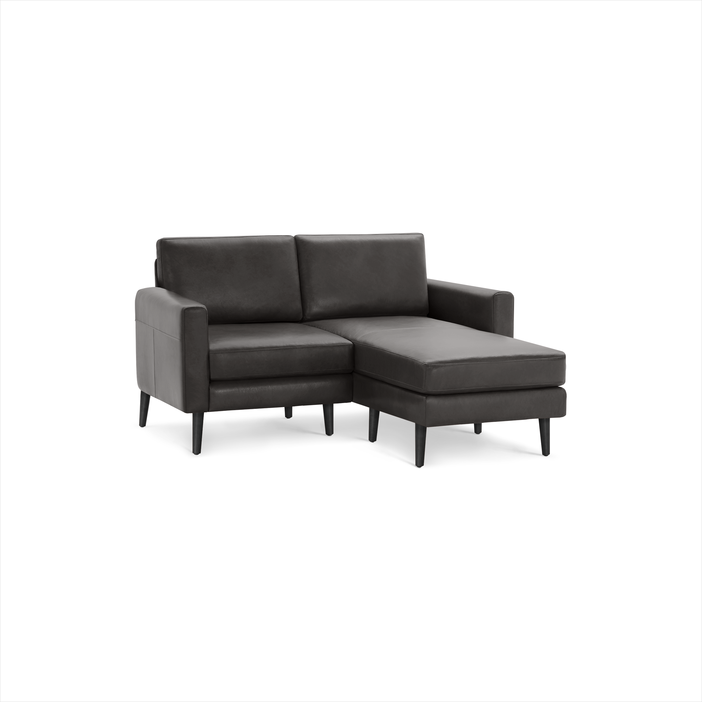 Modern dark gray leather sectional sofa with chaise lounge, straight armrests, and slim black legs on a black background.