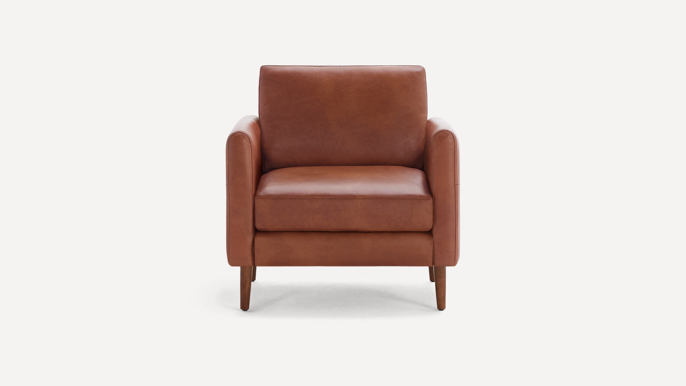 Front view of a mid-century modern brown leather armchair with wooden legs and cushioned seat and backrest.
