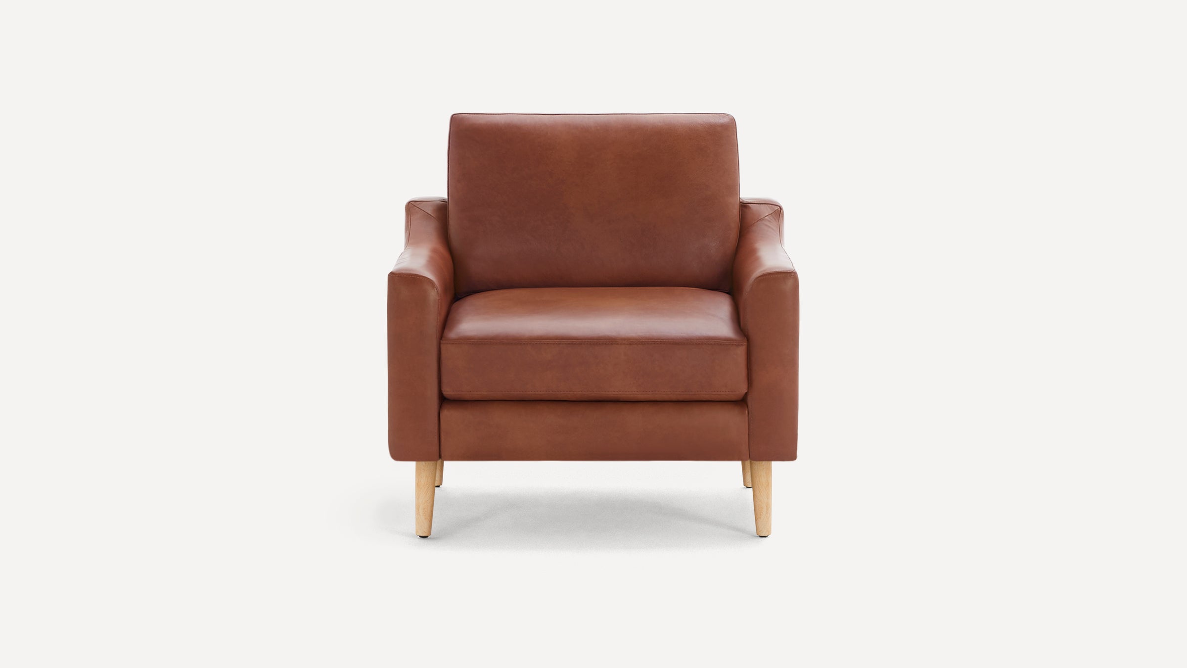Front view of a mid-century modern style armchair featuring smooth brown leather upholstery and wooden legs.