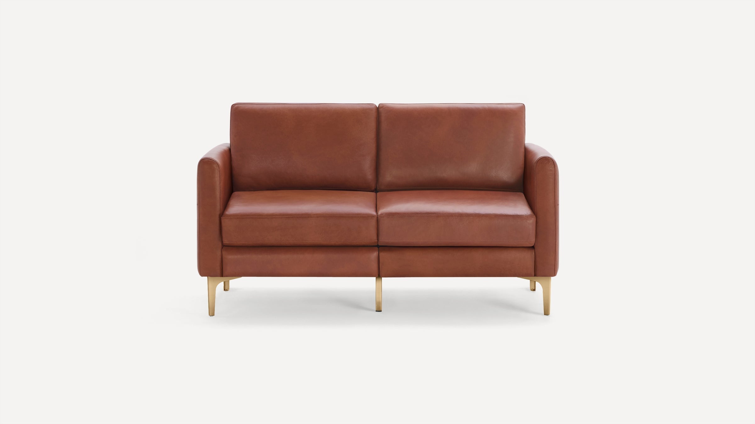 Modern two-seater sofa with smooth brown leather upholstery and slim gold metal legs, set against a plain white background.