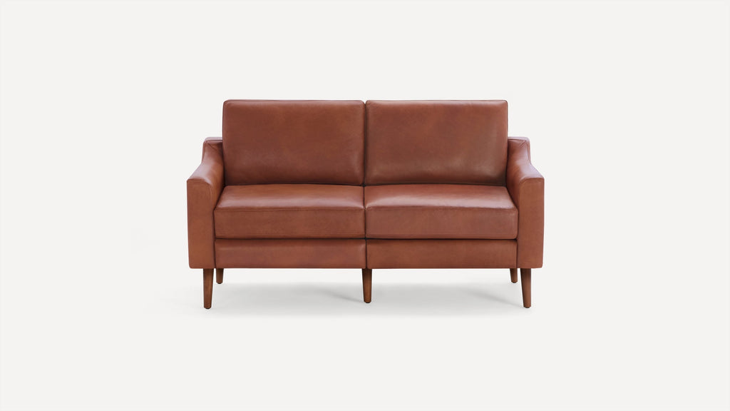 Mid-century style brown leather loveseat with square arms, wooden tapered legs, and cushioned seat and backrest.