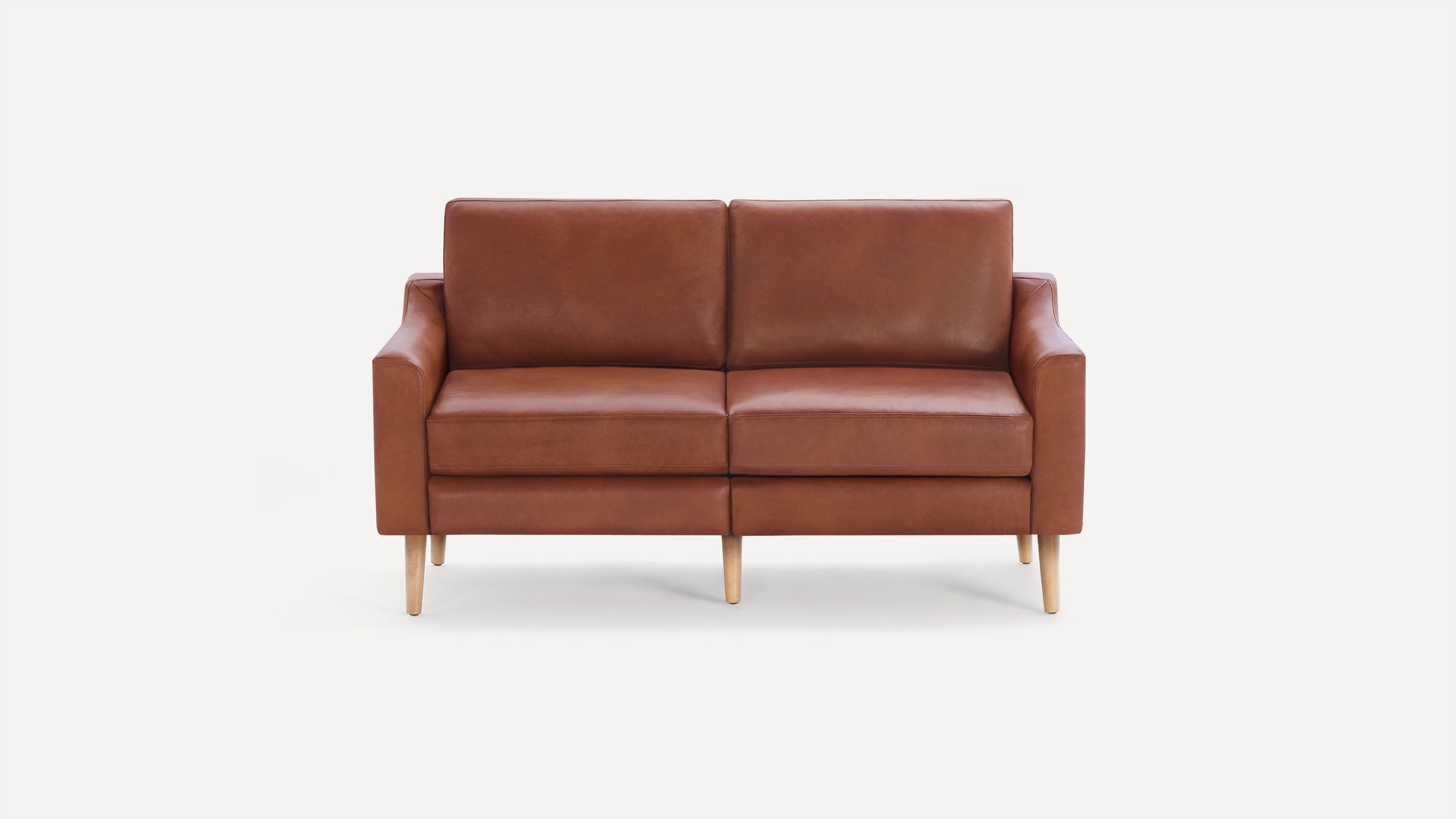 Brown leather two-seater sofa with wooden tapered legs, featuring clean lines and a modern minimalist design on a white background.
