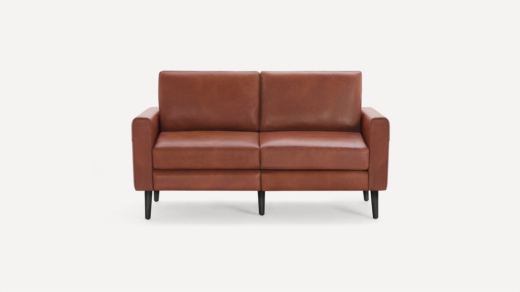Two-seater brown leather sofa with clean lines, black tapered legs, and cushioned seats and backrests.