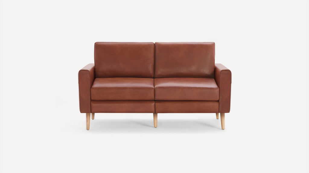 Modern two-seater sofa upholstered in brown leather with wooden tapered legs and clean, minimalist design.