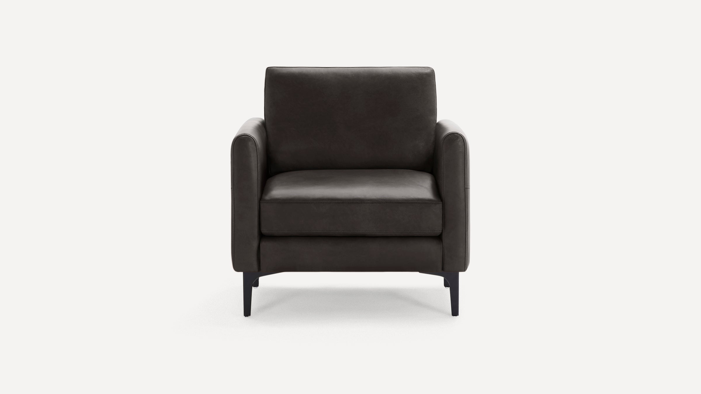 Front view of a modern dark gray leather armchair with straight armrests and slim black legs on a white background.