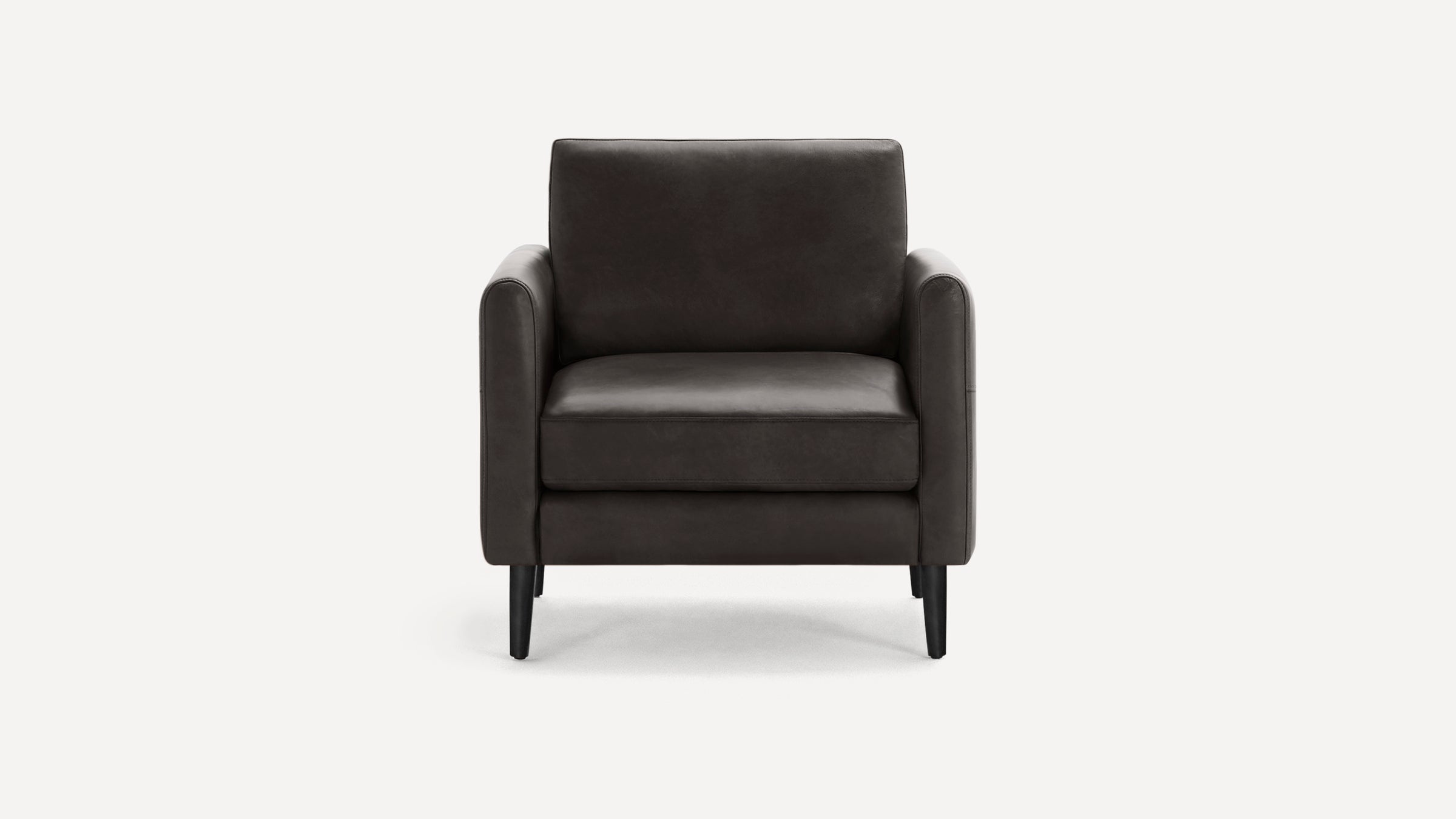 Modern dark brown leather armchair with straight arms, cushioned seat and backrest, supported by four black wooden legs.