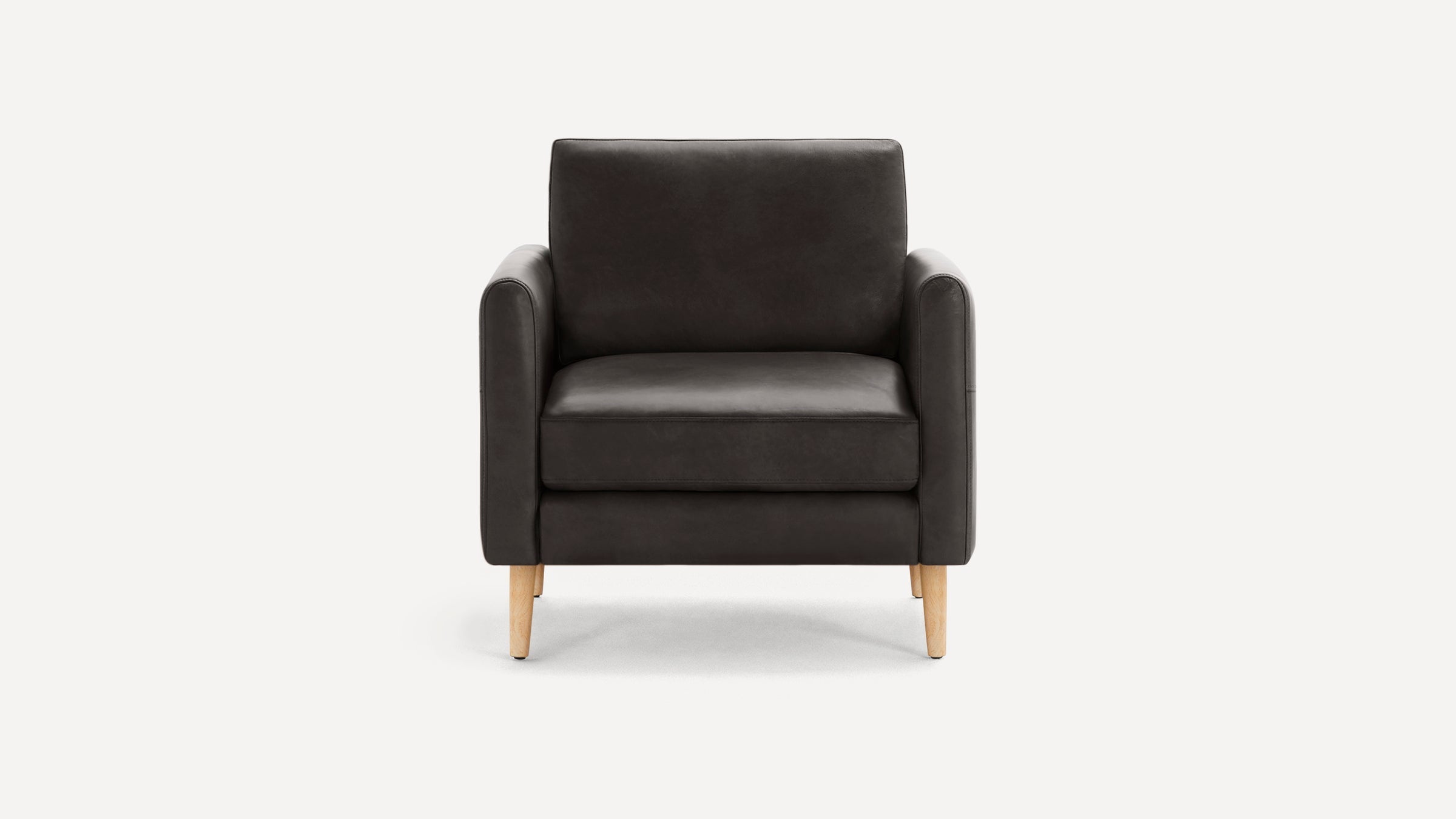 Modern dark gray armchair with cushioned seat and backrest, featuring light wooden legs on a plain white background.