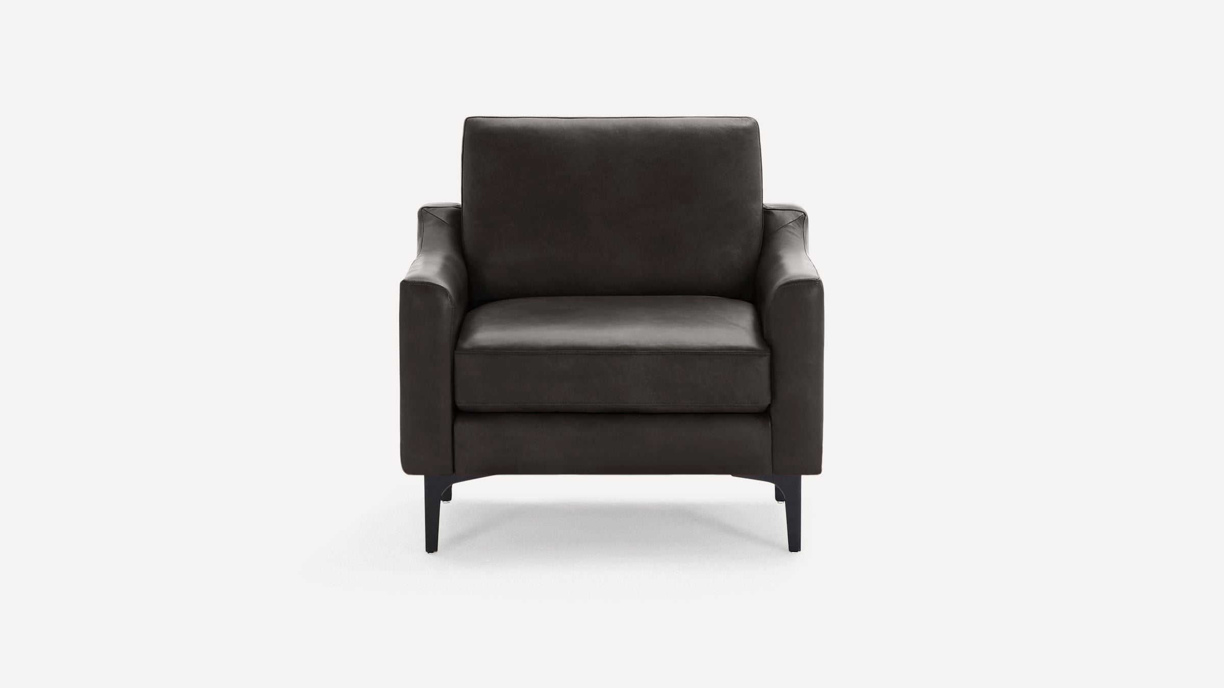 Modern dark brown leather armchair with cushioned seat and backrest, slim armrests, and black tapered metal legs.