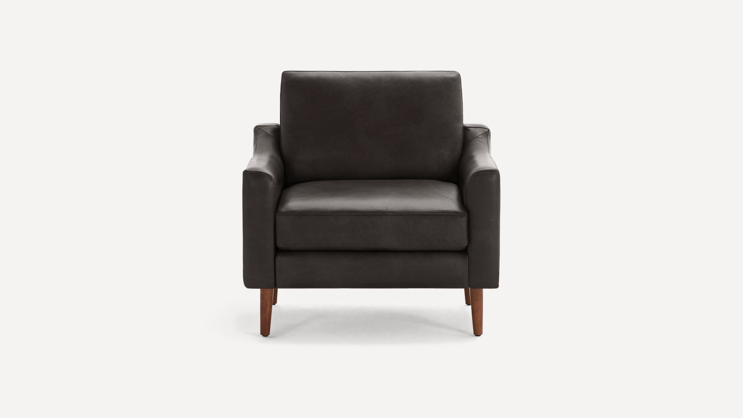 Front view of a modern dark grey leather armchair with straight arms and wooden tapered legs against a white background.
