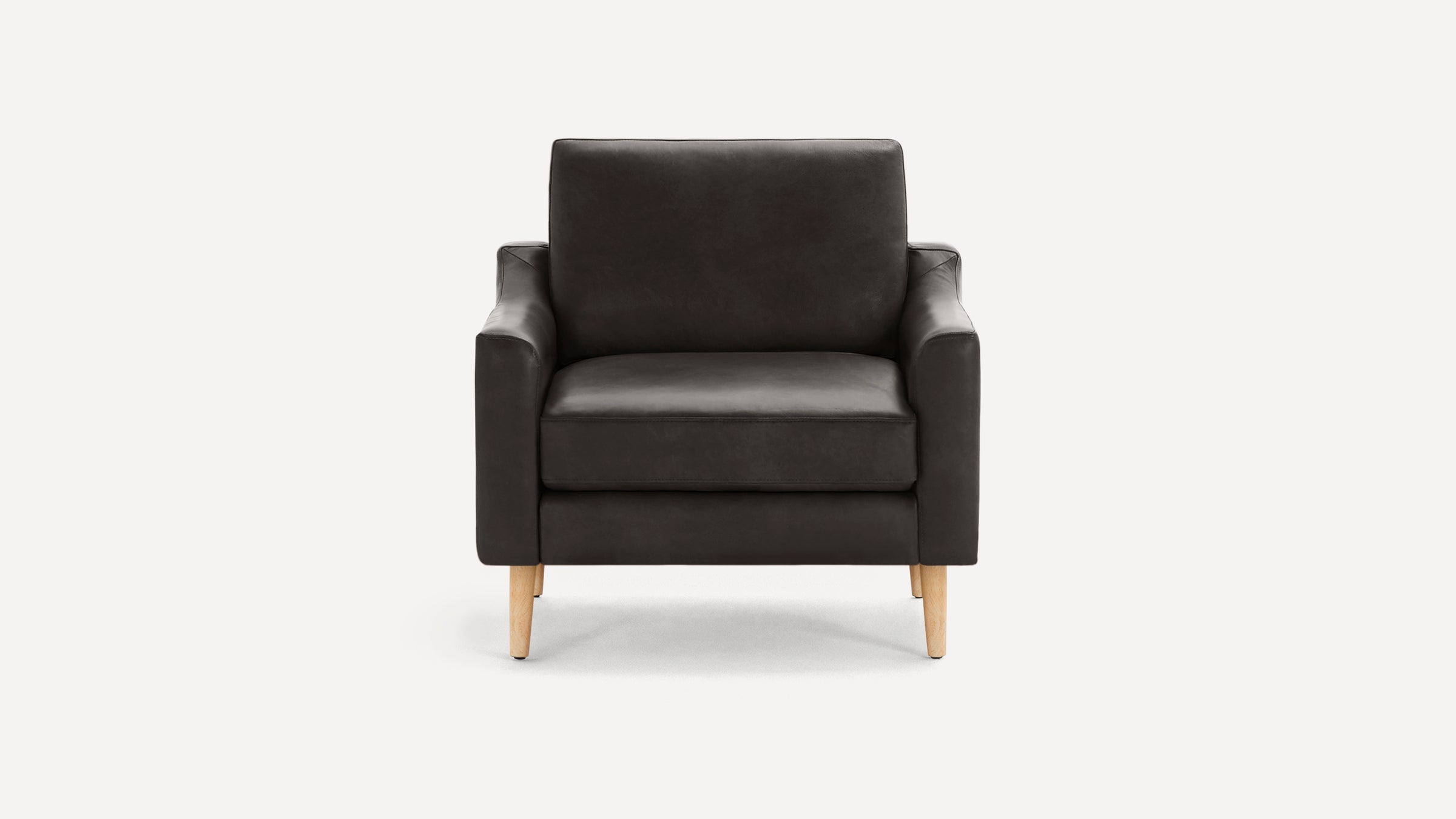 Modern dark gray leather armchair with smooth upholstery, straight arms, and light wooden legs, shown against a plain white background.