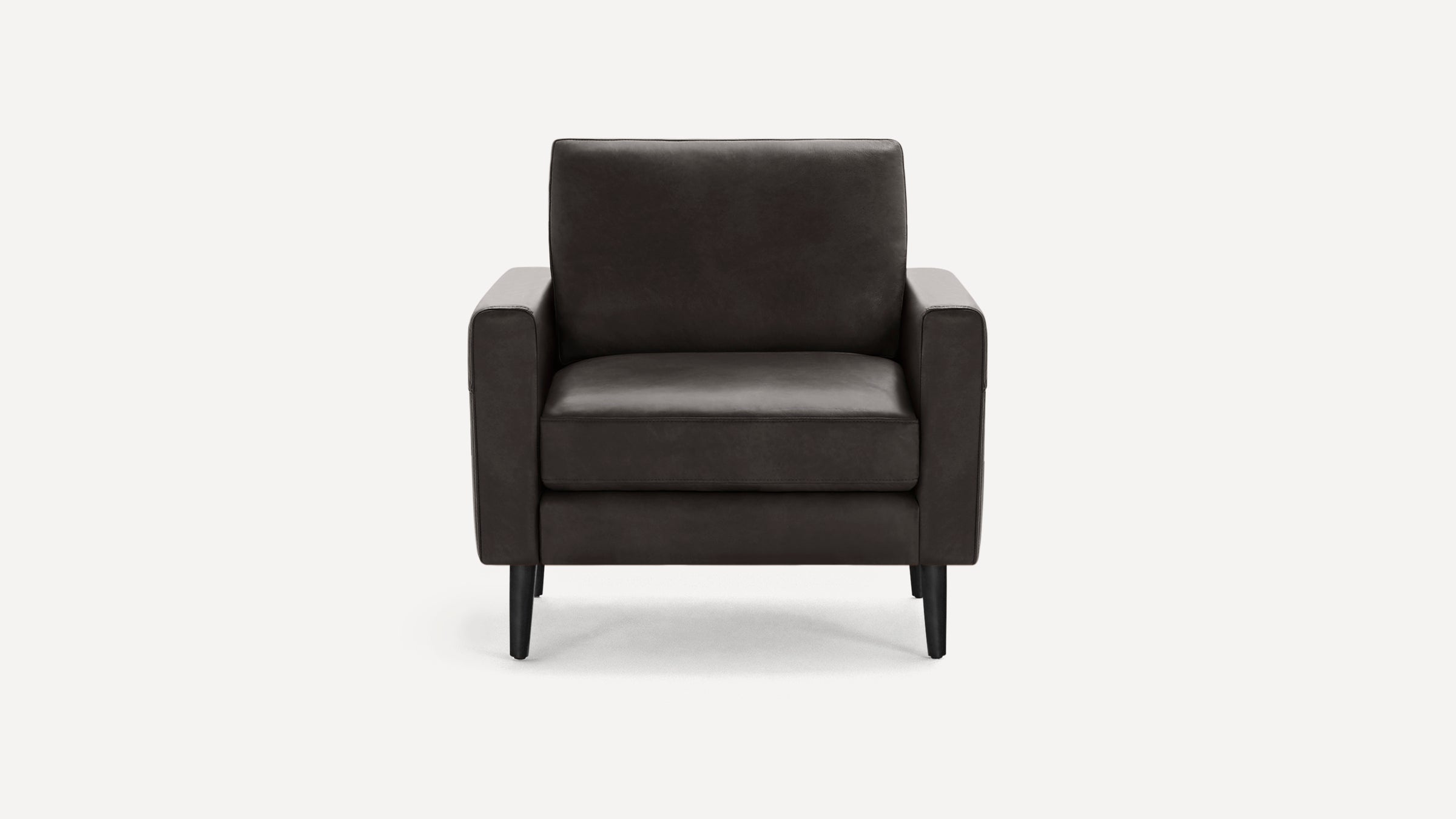 Modern dark brown leather armchair with straight arms and black tapered wooden legs, shown against a white background.