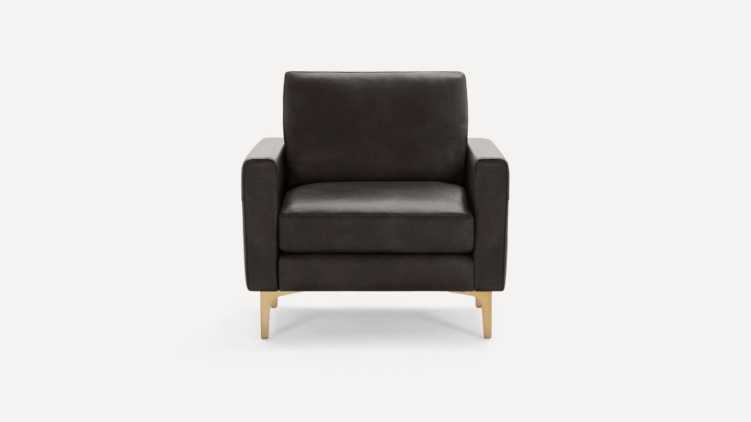 Front view of a modern dark gray leather armchair with square arms and gold metal legs on a white background.