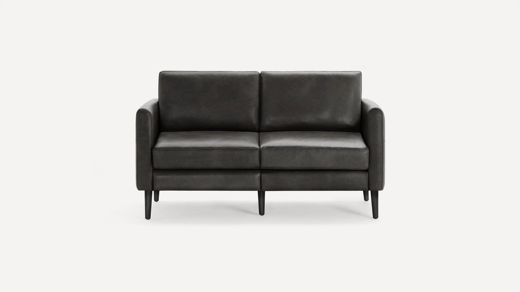Dark gray modern two-seater sofa with clean lines, cushioned back and seat, and tapered black legs on a white background.