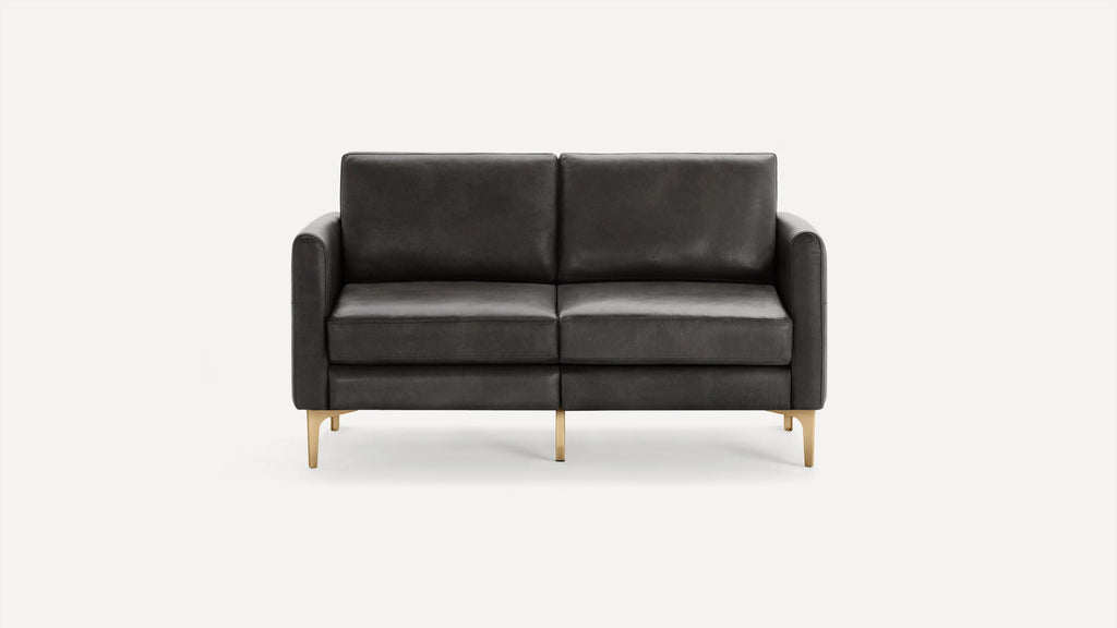 Modern dark gray leather loveseat with clean lines, cushioned seats, and gold-toned metal legs on a white background.