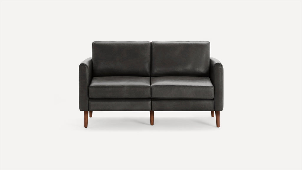 A modern dark grey leather loveseat sofa with wooden legs and clean, minimalist design, shown against a plain white background.