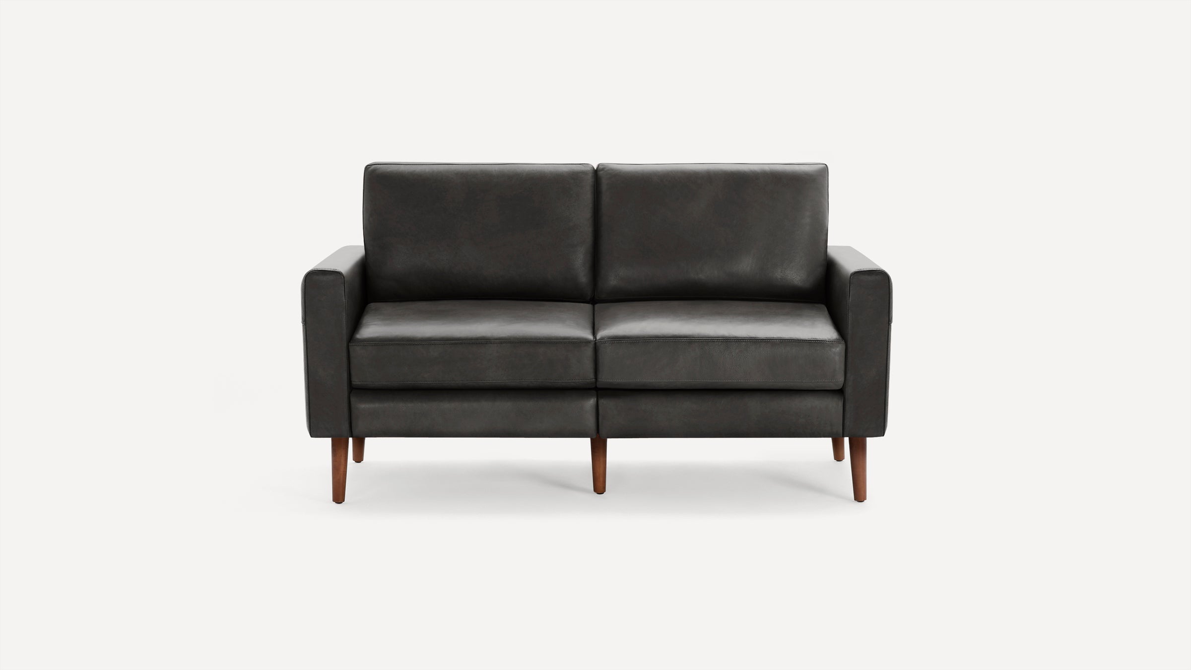 Two-seater black leather sofa with clean lines and wooden legs on a white background.