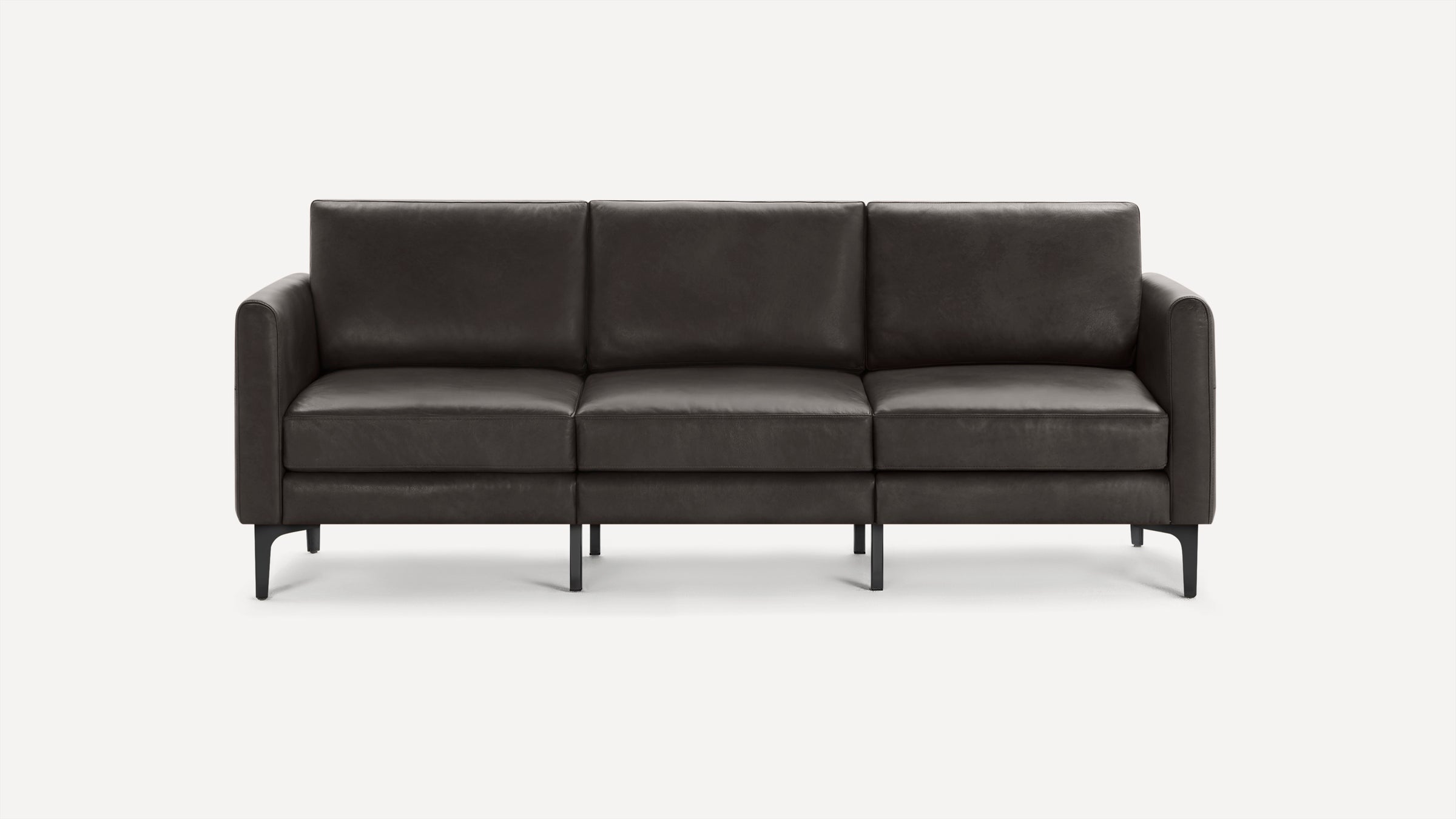Modern three-seater sofa with dark gray leather upholstery and slim black metal legs against a plain white background.