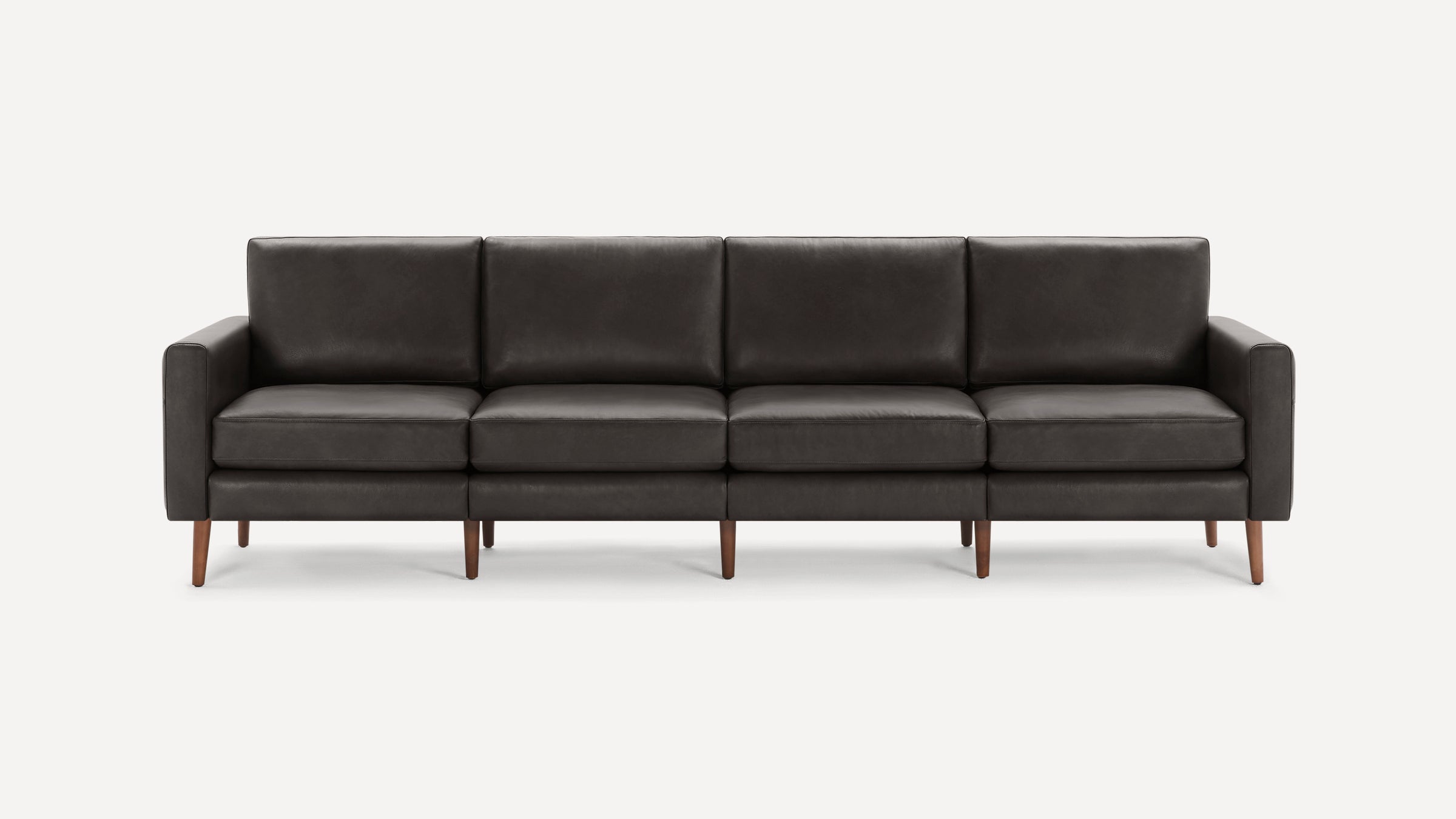 Modern dark gray leather four-seater sofa with clean lines, cushioned seats, and wooden tapered legs on white background.