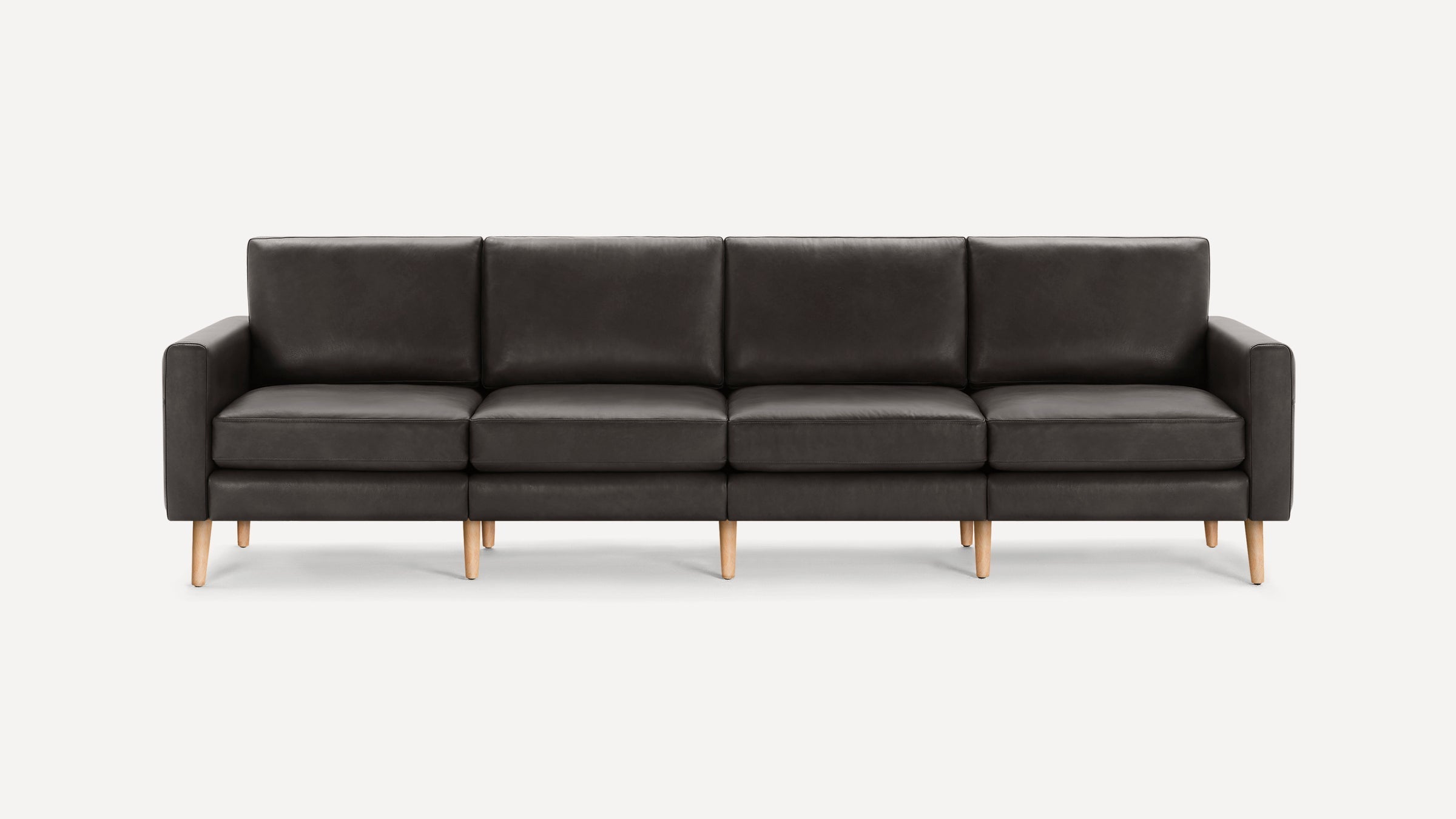 Modern four-seater sofa with dark gray leather upholstery and light wooden legs, featuring clean lines and cushioned armrests.