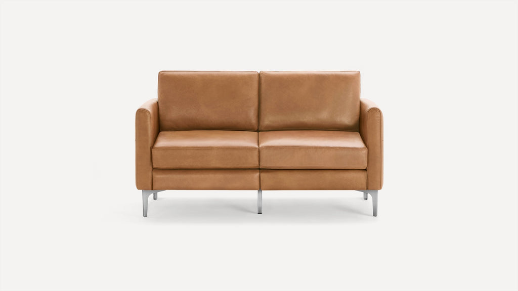 Modern two-seater sofa with tan leather upholstery, rectangular cushions, armrests, and silver metal legs against a plain white background.