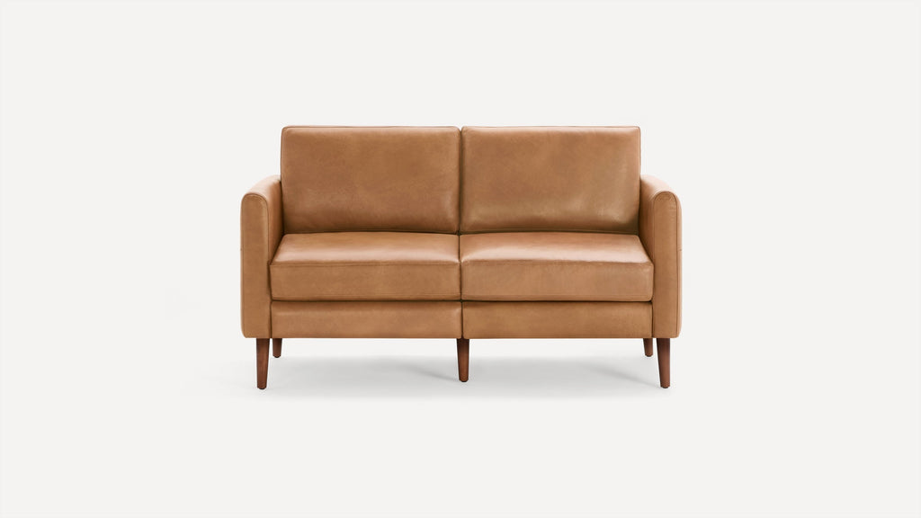 Two-seater sofa with tan leather upholstery and wooden tapered legs, featuring clean, modern lines and plush cushions.