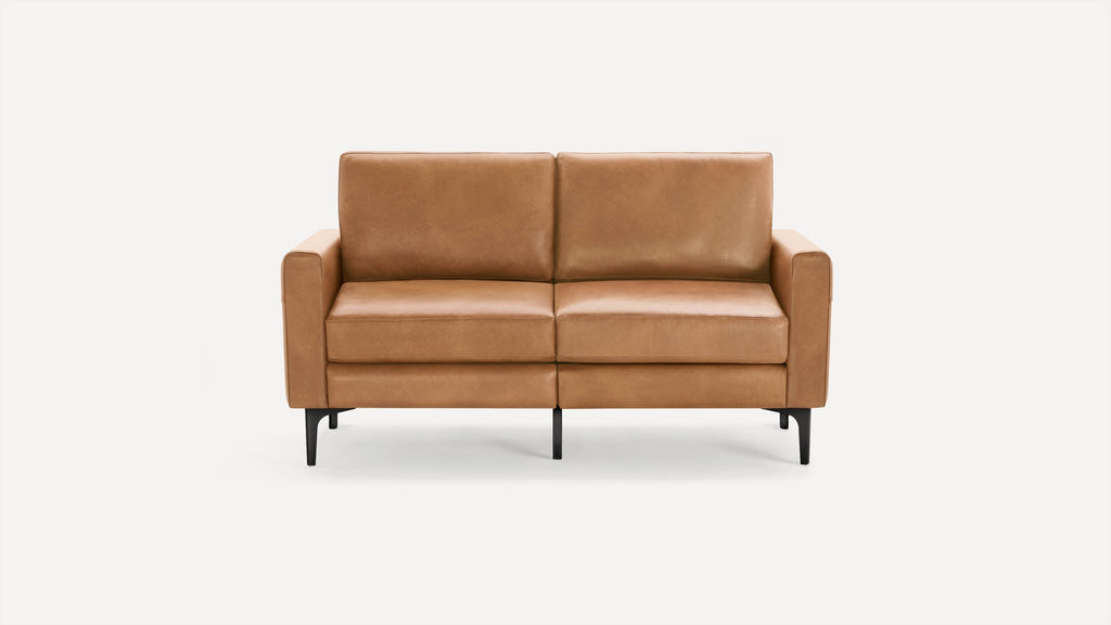 Modern two-seater sofa with tan leather upholstery, straight arms, cushioned seats, and black tapered legs on a white background.