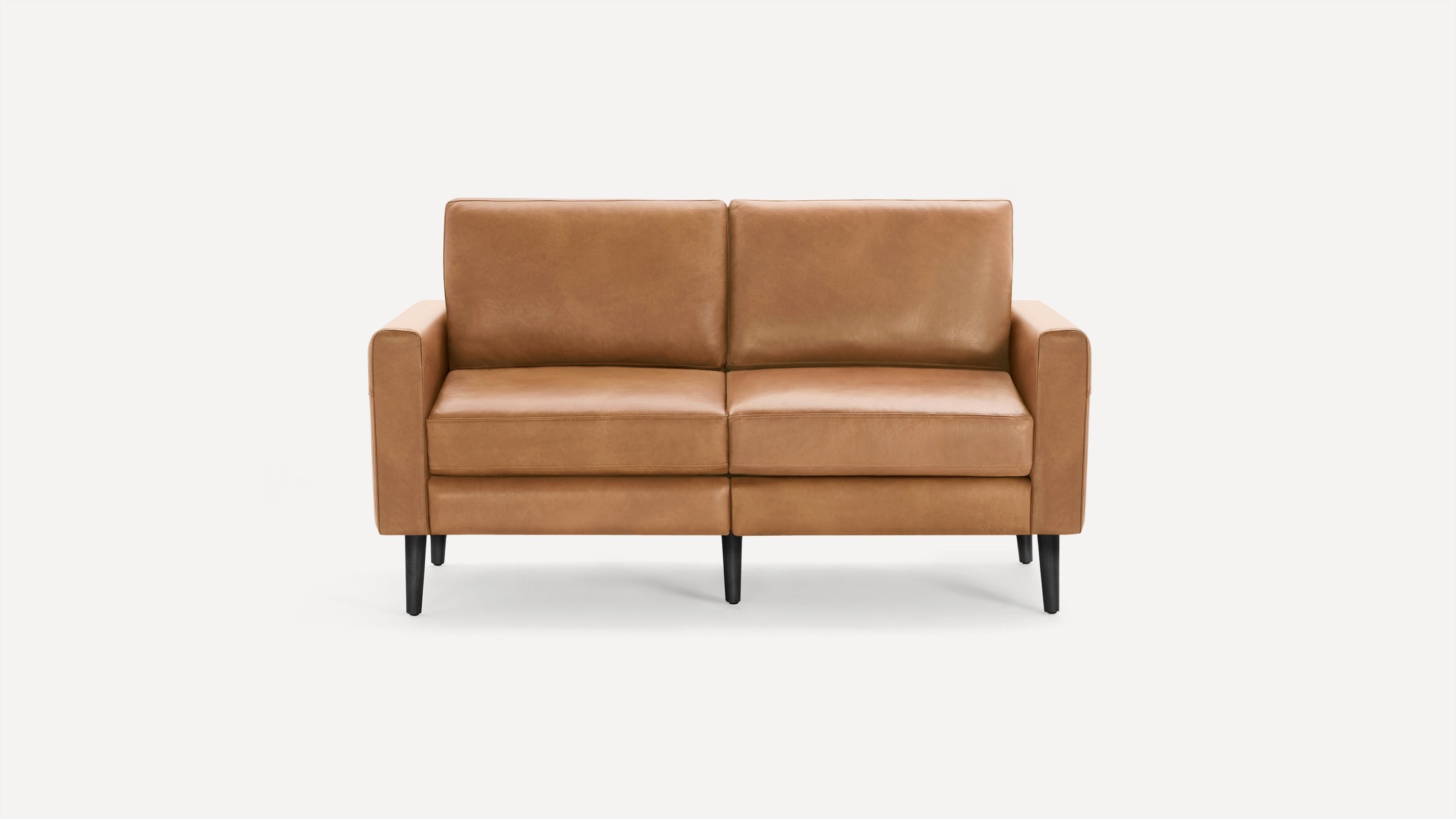 Modern two-seater sofa with light brown leather upholstery and black tapered wooden legs, set against a plain white background.