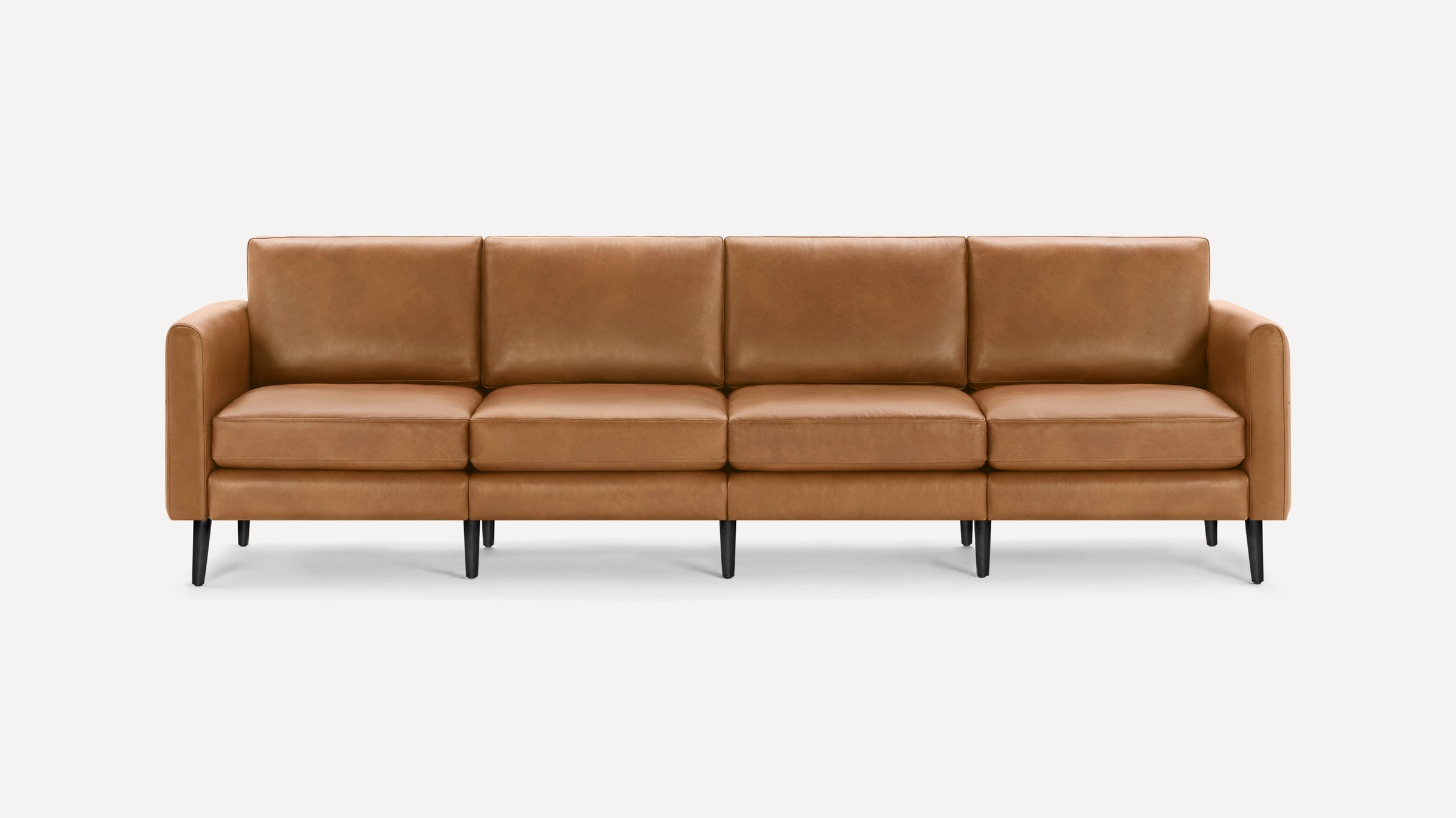 Four-seater modern sofa with light brown leather upholstery and black tapered wooden legs on a white background.
