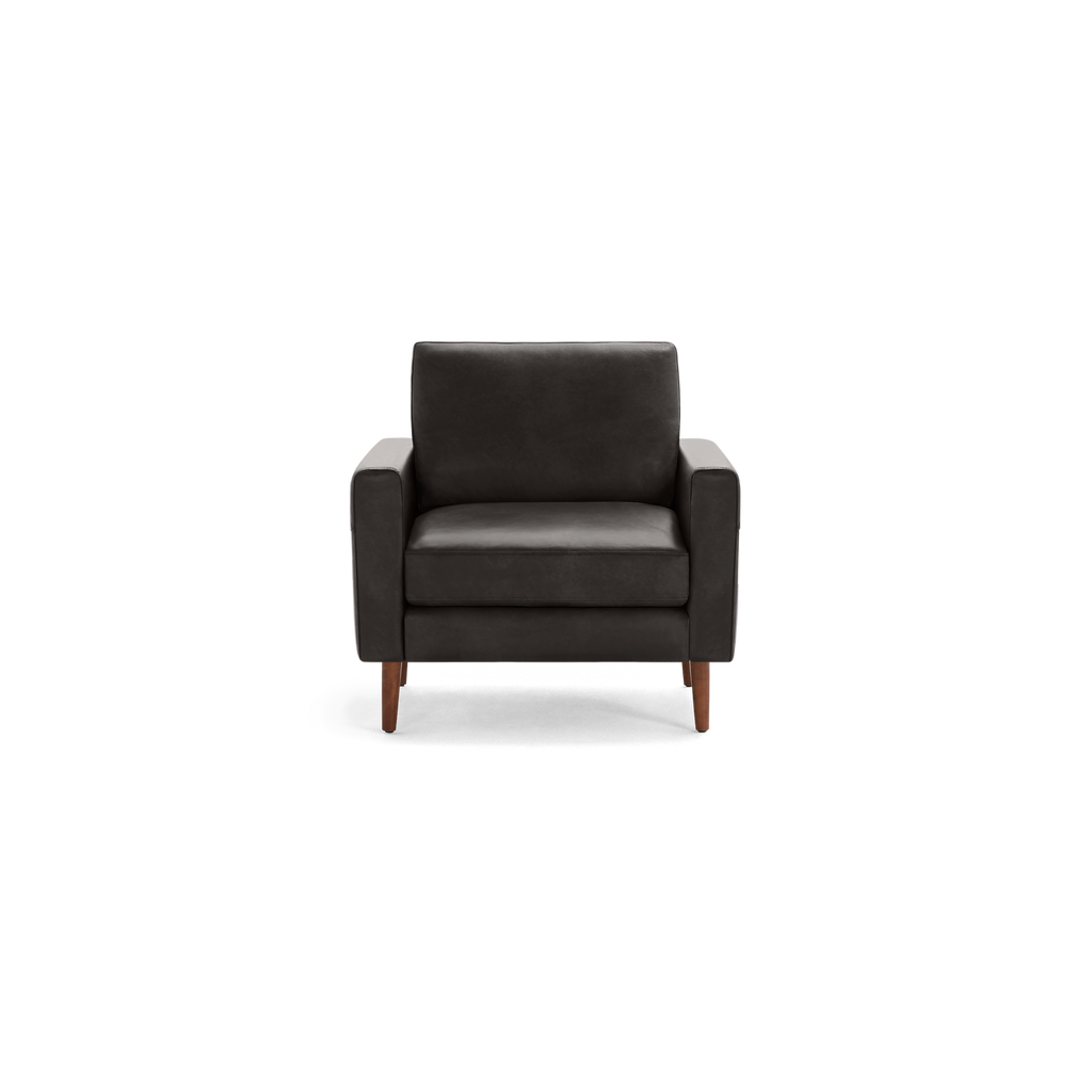 Modern dark gray upholstered armchair with wooden legs, featuring a cushioned seat, backrest, and squared armrests.