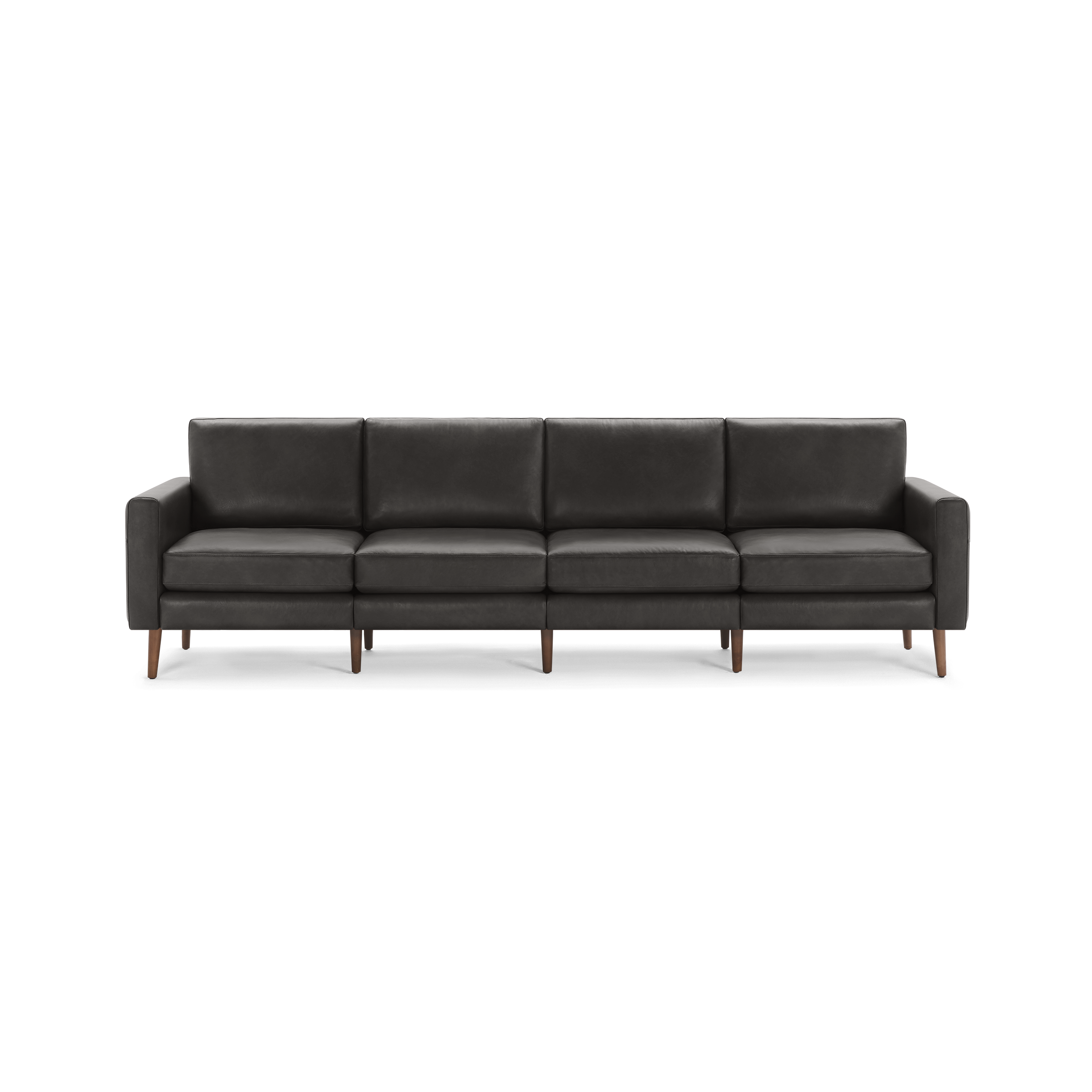 Modern long dark gray leather sofa with four seat cushions, straight armrests, and wooden legs, isolated on a white background.