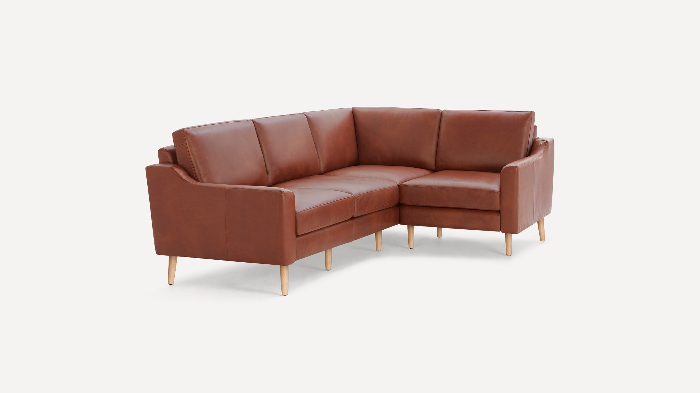 Brown leather L-shaped sectional sofa with wooden legs, featuring clean lines and a modern design.