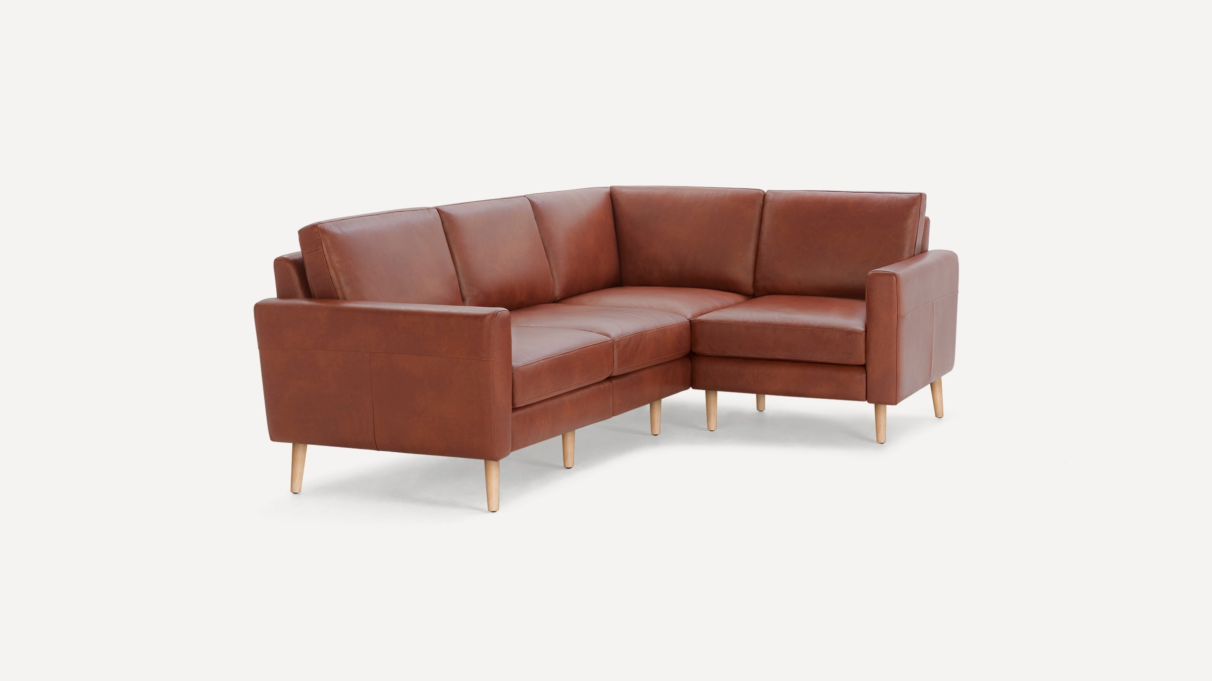 Brown leather L-shaped sectional sofa with wooden legs, modern design, cushioned seating and backrest, minimalistic and stylish.