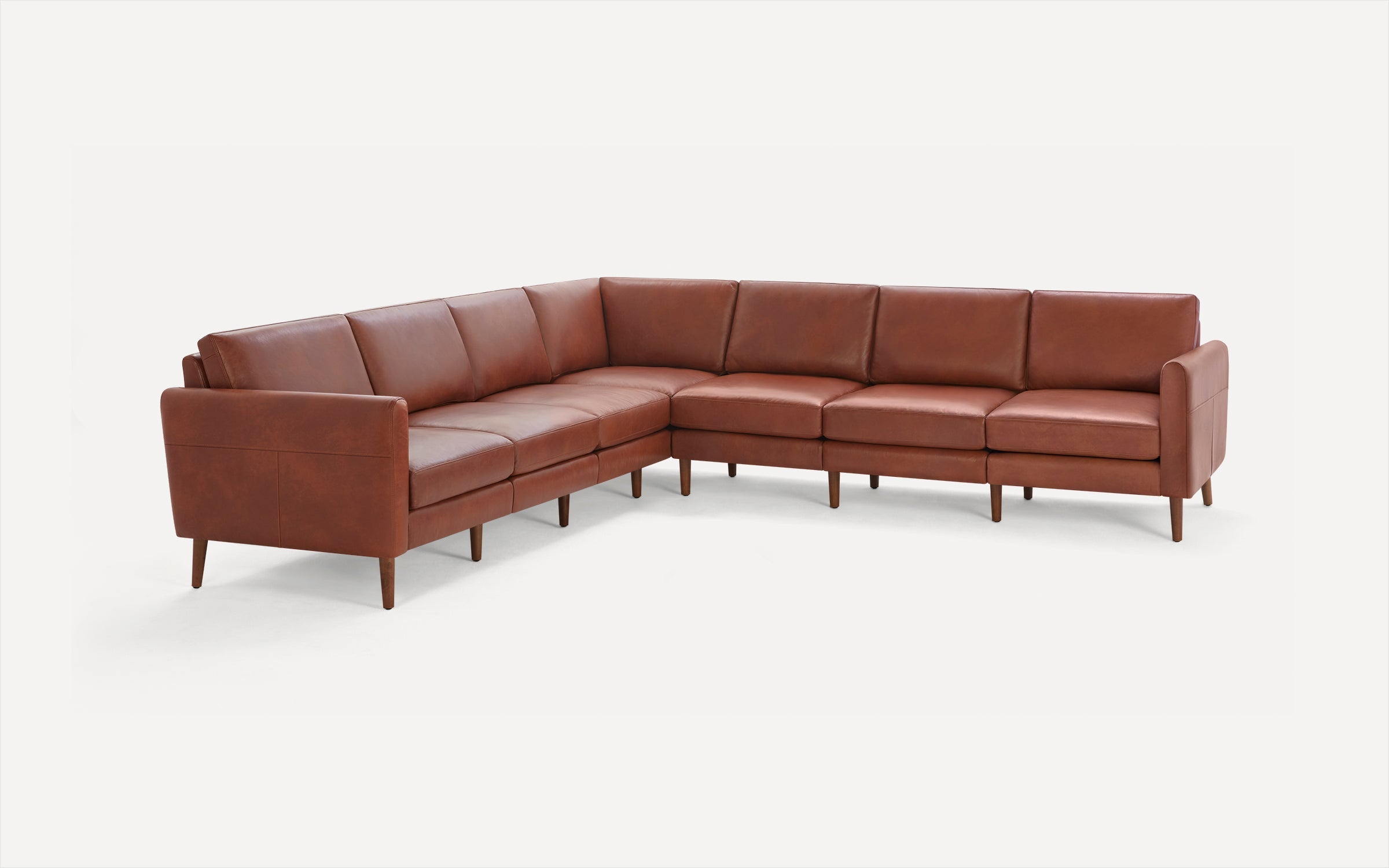 Brown leather L-shaped sectional sofa with clean lines and wooden tapered legs on a white background.