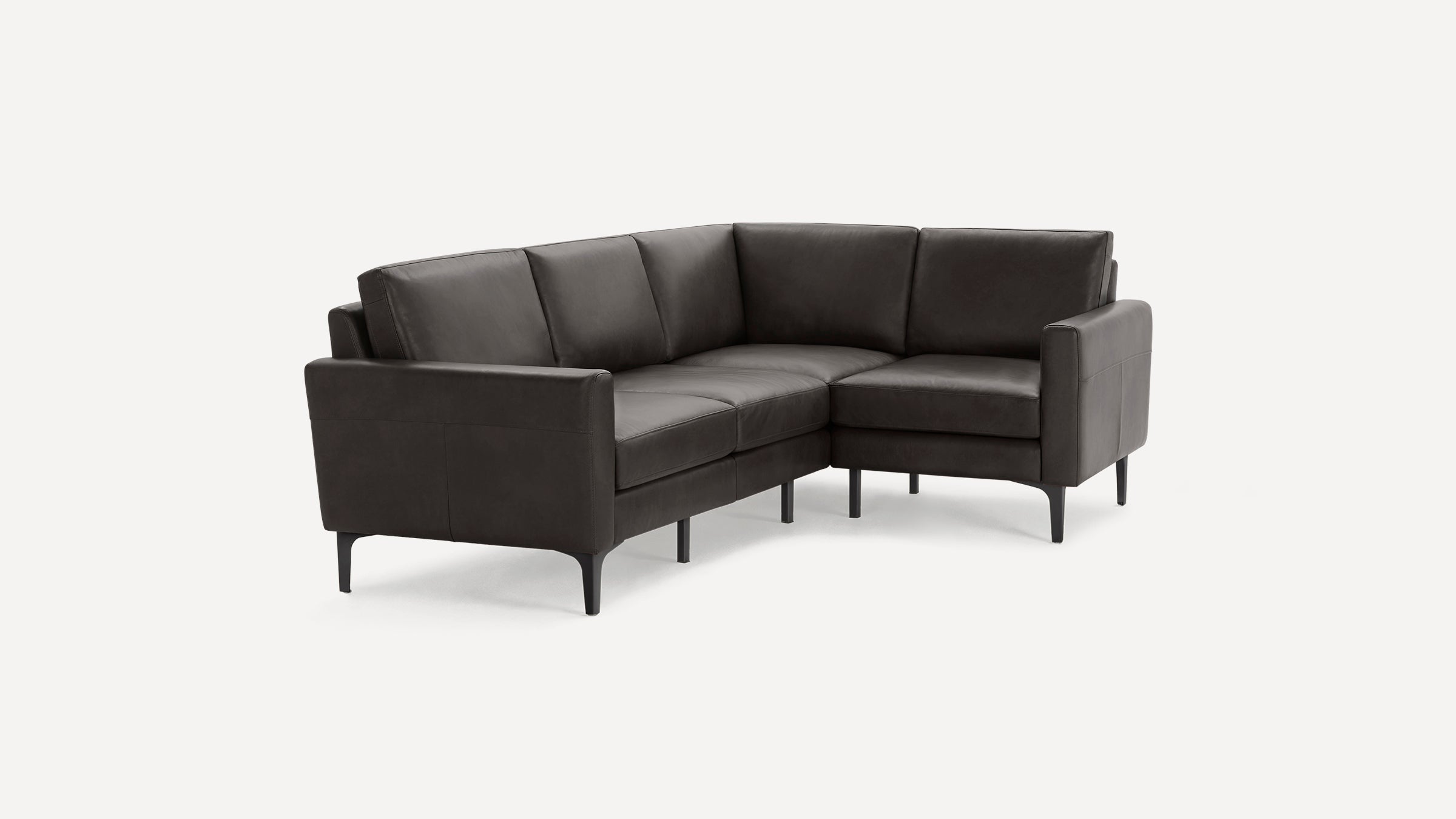 Modern dark gray leather sectional sofa with clean lines, angled back cushions, and slim black metal legs on white background.